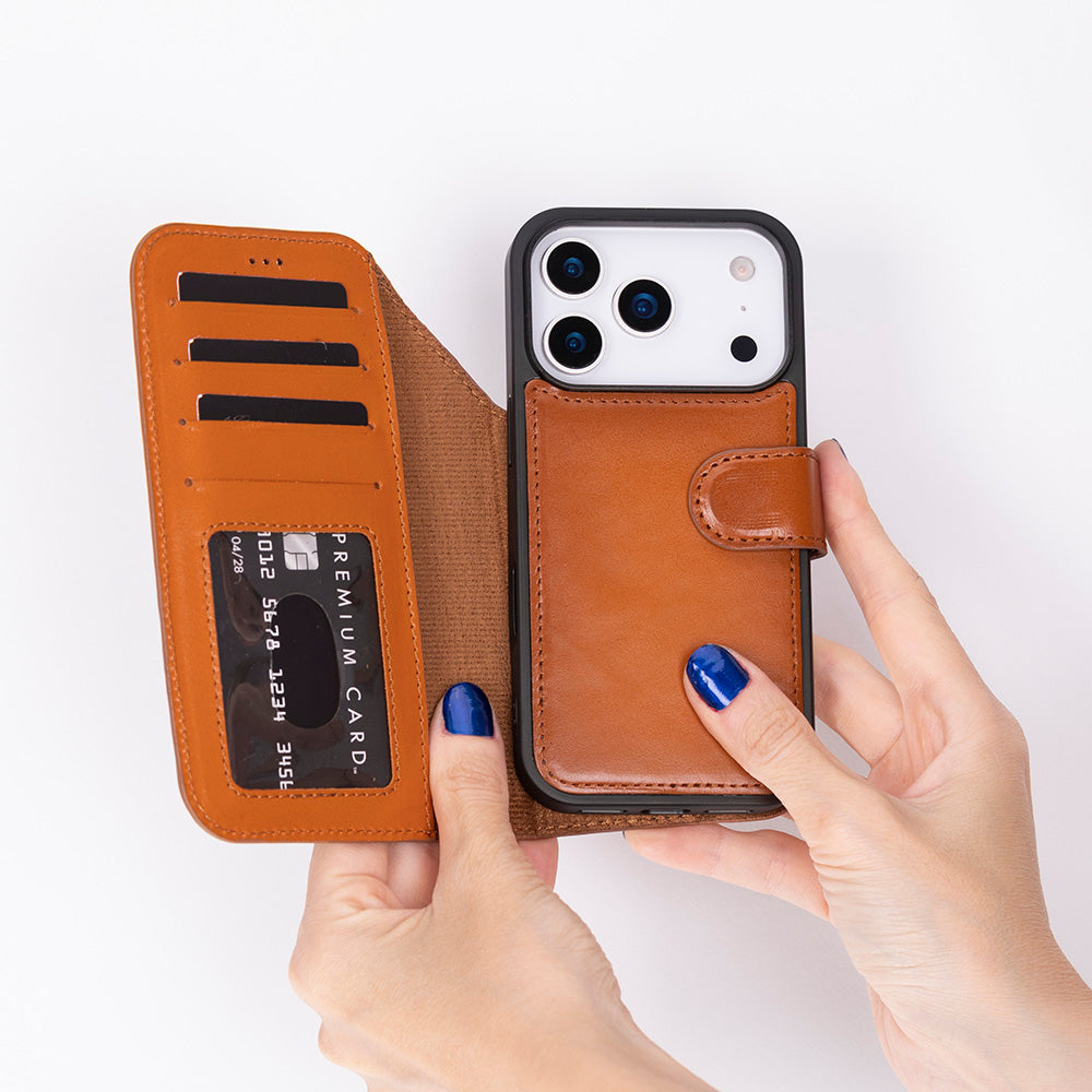 Eller, kart yuvalı kahverengi deri iPhone cüzdan kılıfını tutuyor.