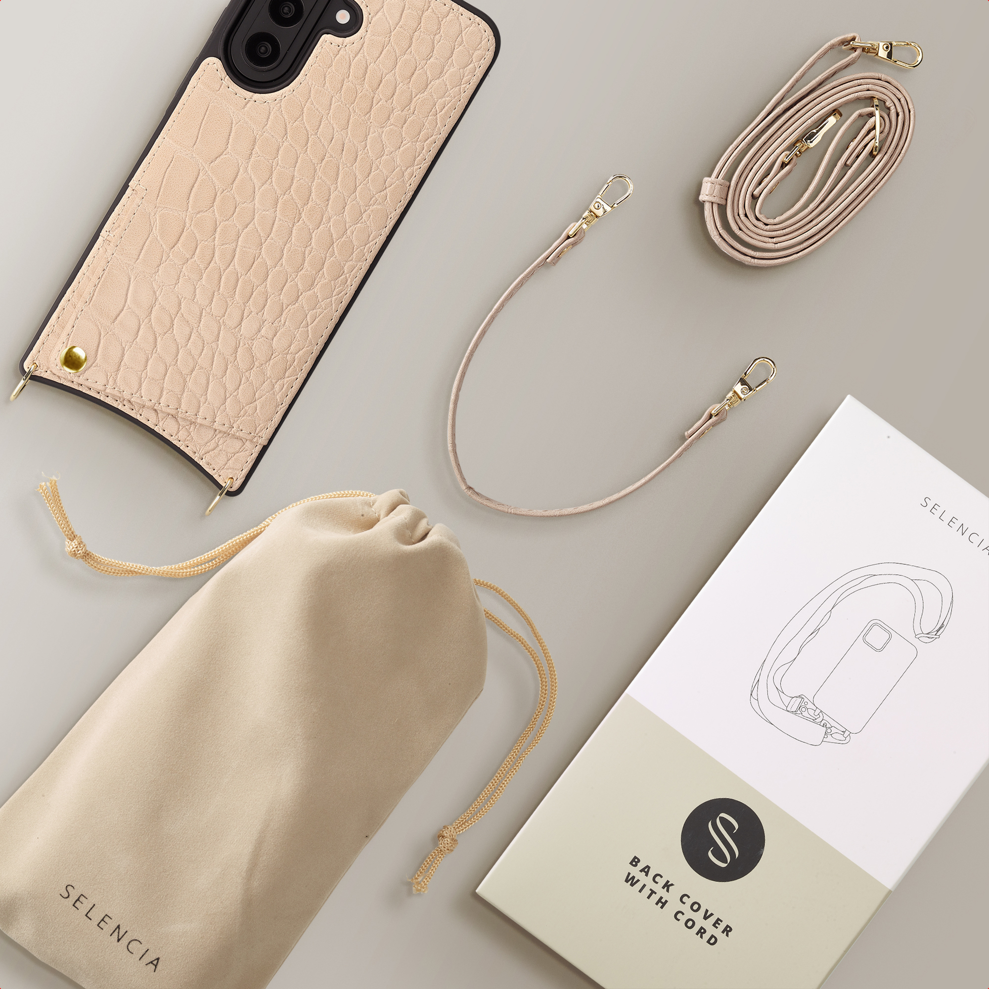 Una custodia per telefono beige effetto coccodrillo con cordino, pochette e scatola.