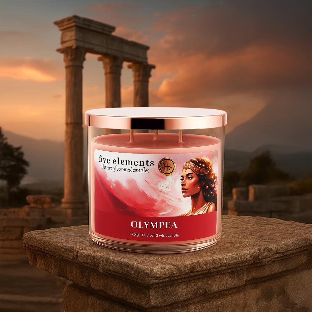 Eine Duftkerze mit dem Etikett 'Olympia' steht auf einem Stein.