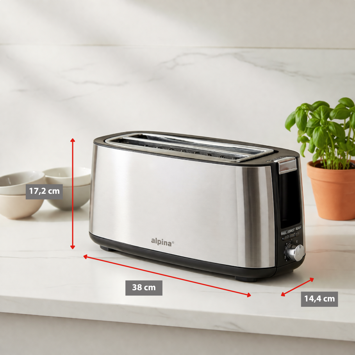 Silberner Zweischlitztoaster mit Bedienelementen, daneben Schalen und eine Pflanze.