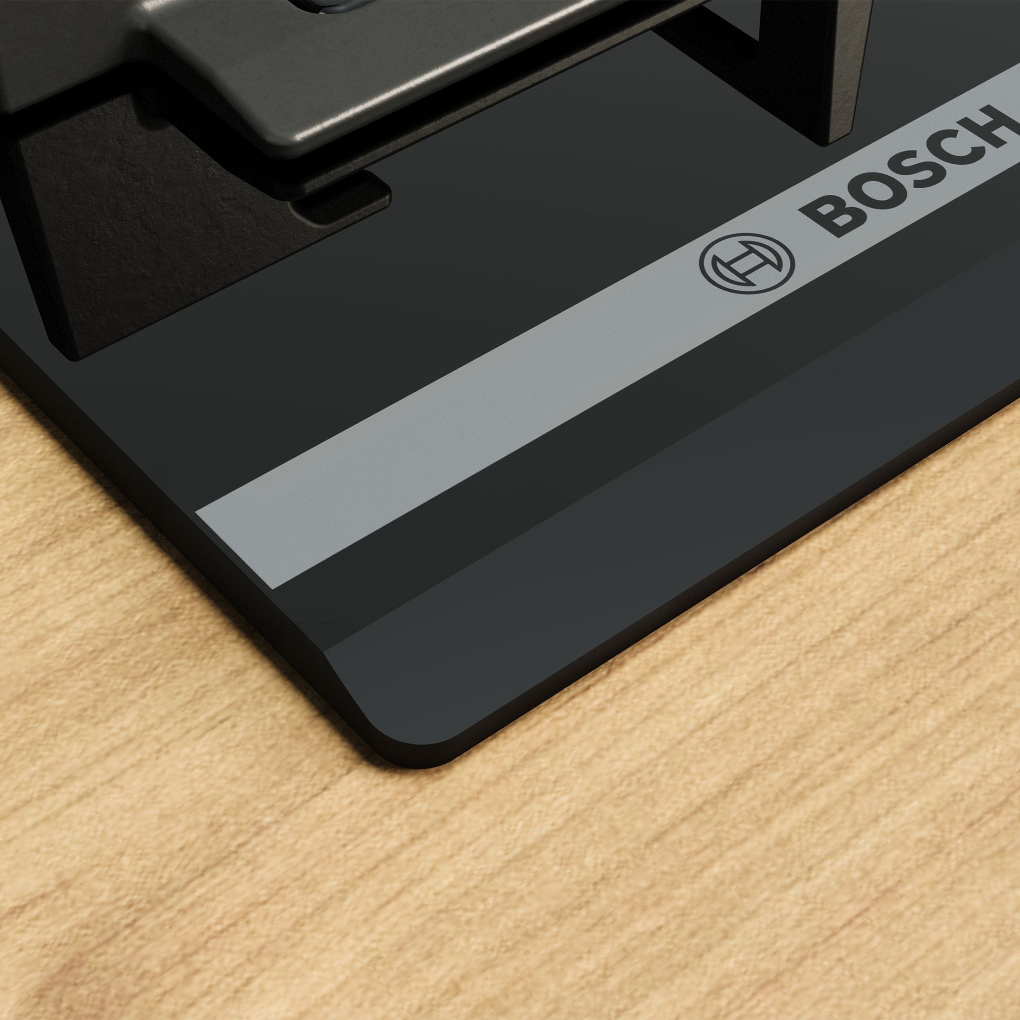 Czarny sprzęt Bosch na drewnianej powierzchni z szarymi paskami.