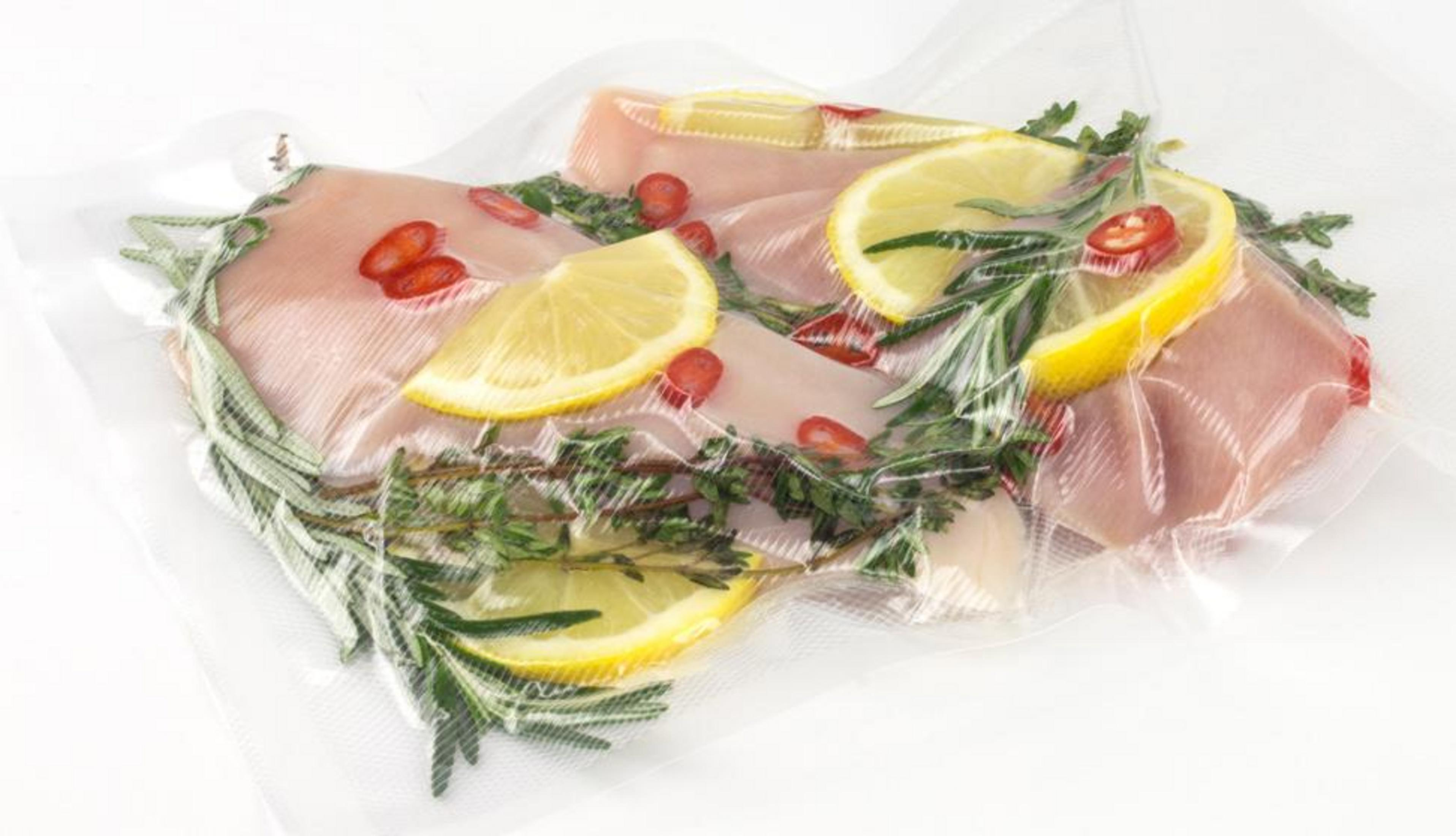 Pollo sottovuoto con fette di limone, peperoncino ed erbe aromatiche.