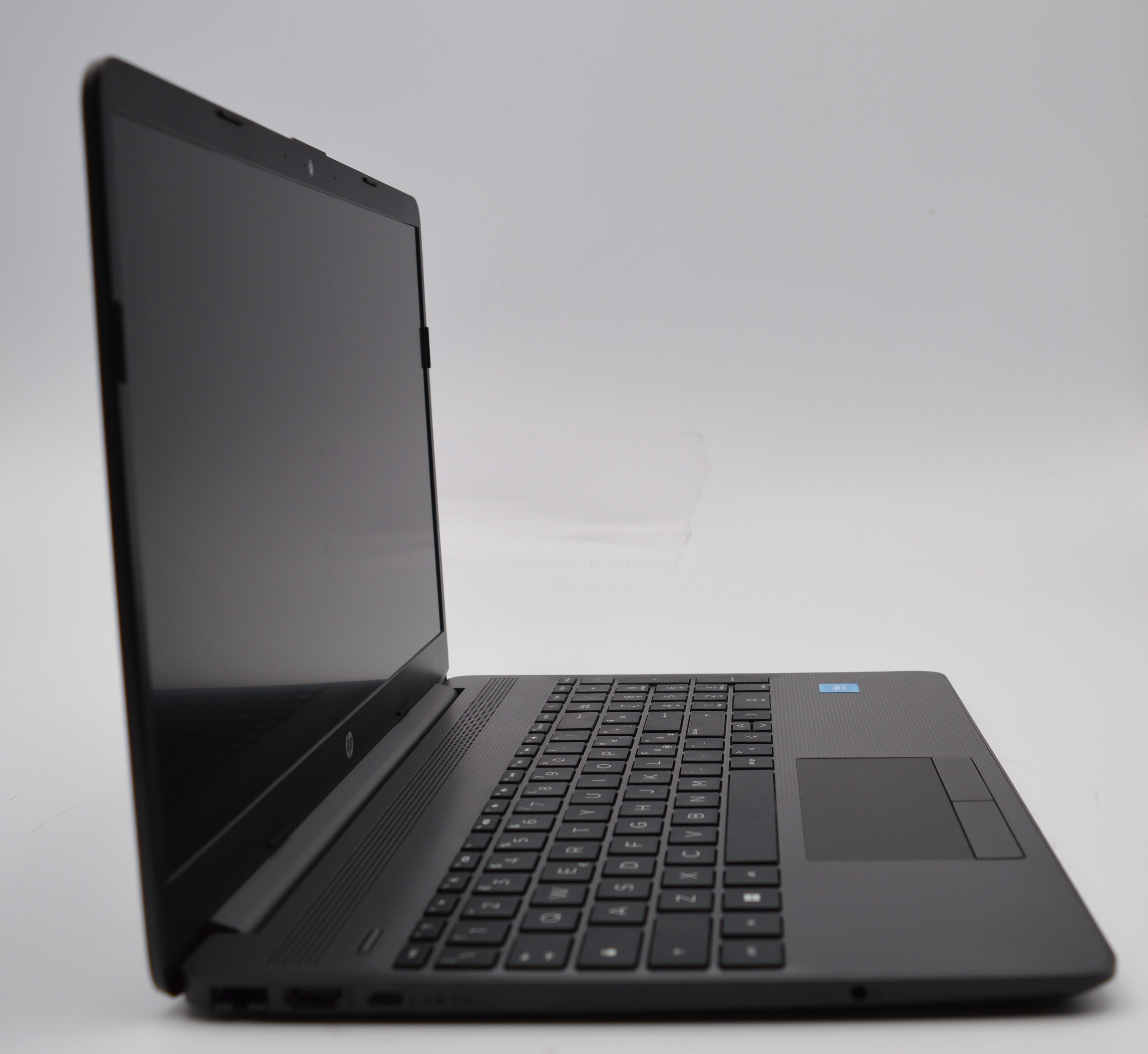 Ein schwarzer Laptop mit beleuchteter Tastatur und Touchpad auf weißem Hintergrund.