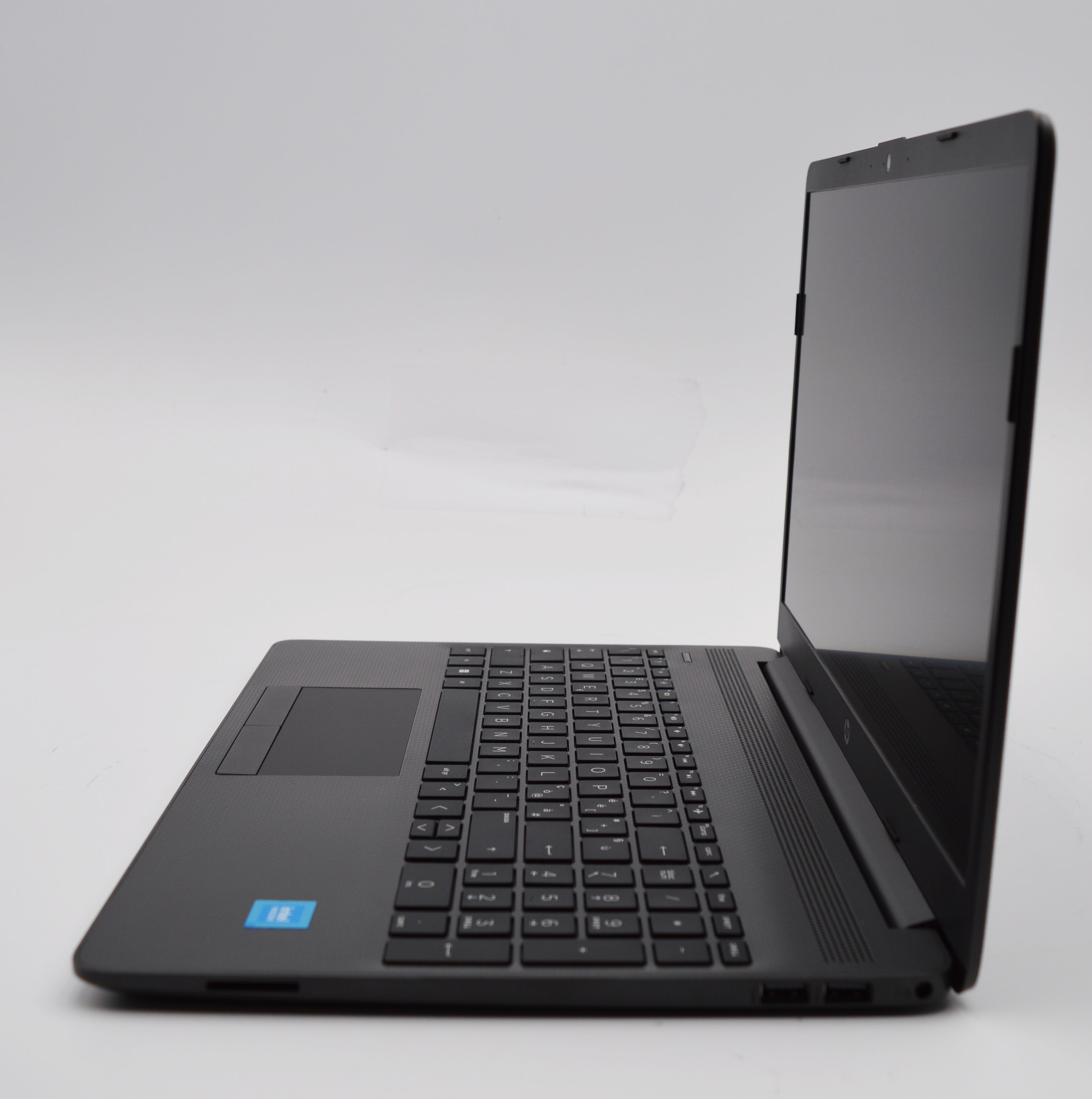 Schwarzer Laptop im Profil auf weißem Hintergrund, Tastatur und Touchpad sichtbar.
