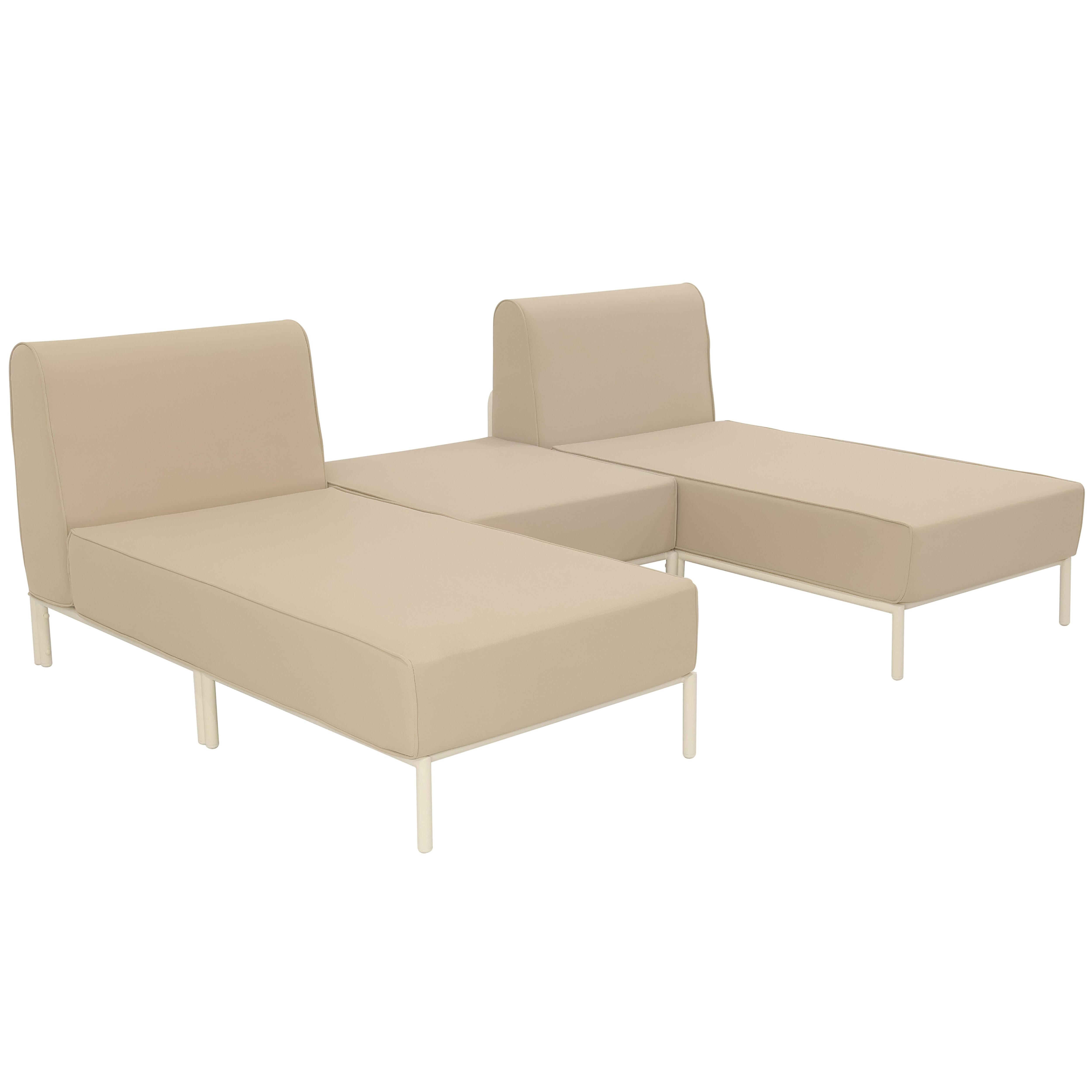 Ein beiges Modulsofa mit weißem Metallrahmen und schlanken Beinen.