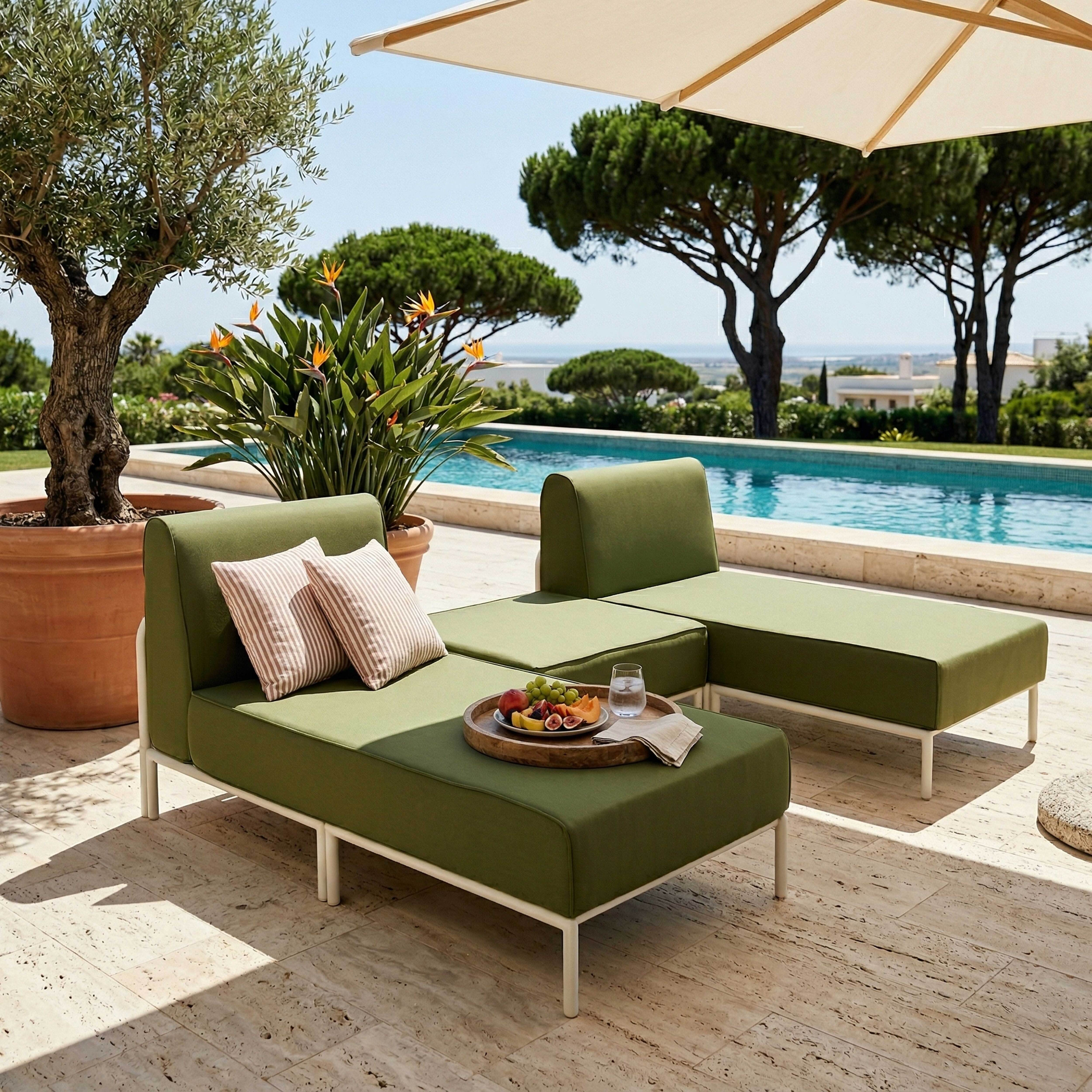 Grüne Lounge-Möbel am Pool mit Obst und Getränken, Sonnenschirm und Bäumen.
