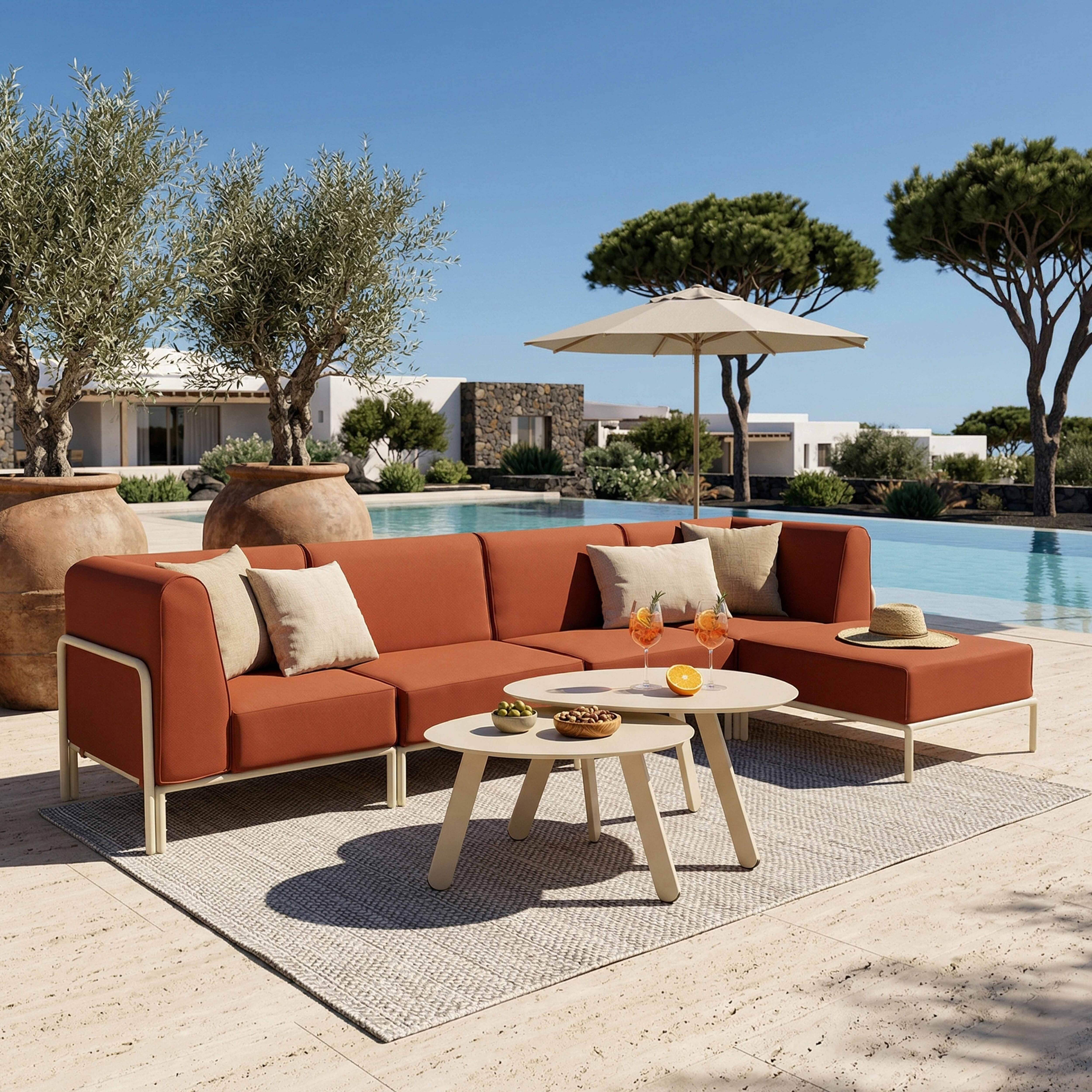 Orange Lounge-Möbel am Pool mit zwei Couchtischen, Getränken und einem Hut.