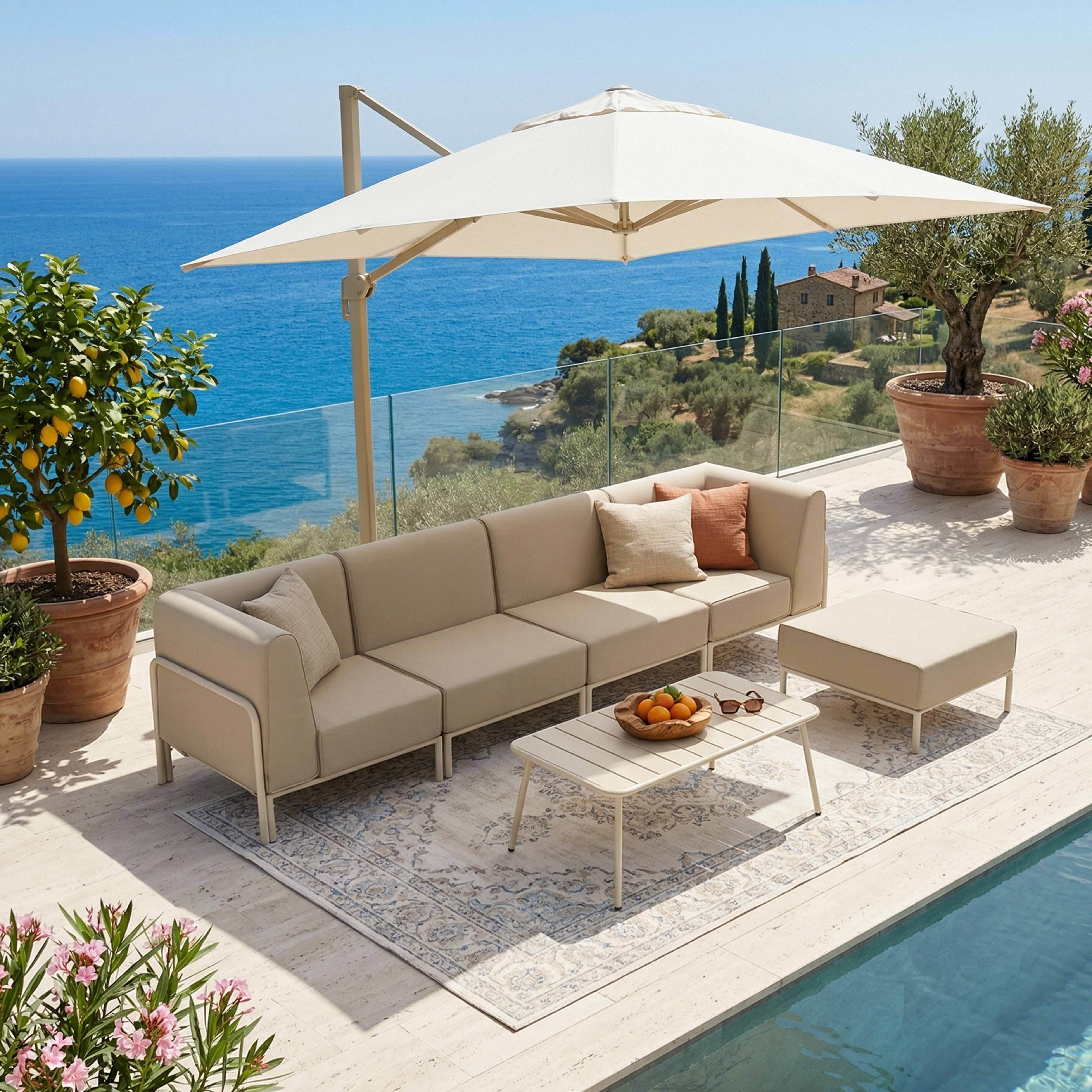 Eine beige Lounge-Garnitur am Pool mit Blick auf das Meer, Sonnenschirm und Zitronenbaum.