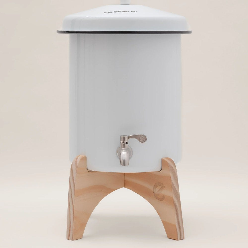 Ein weißer Keramik-Wasserbehälter mit Zapfhahn auf einem Holzständer.