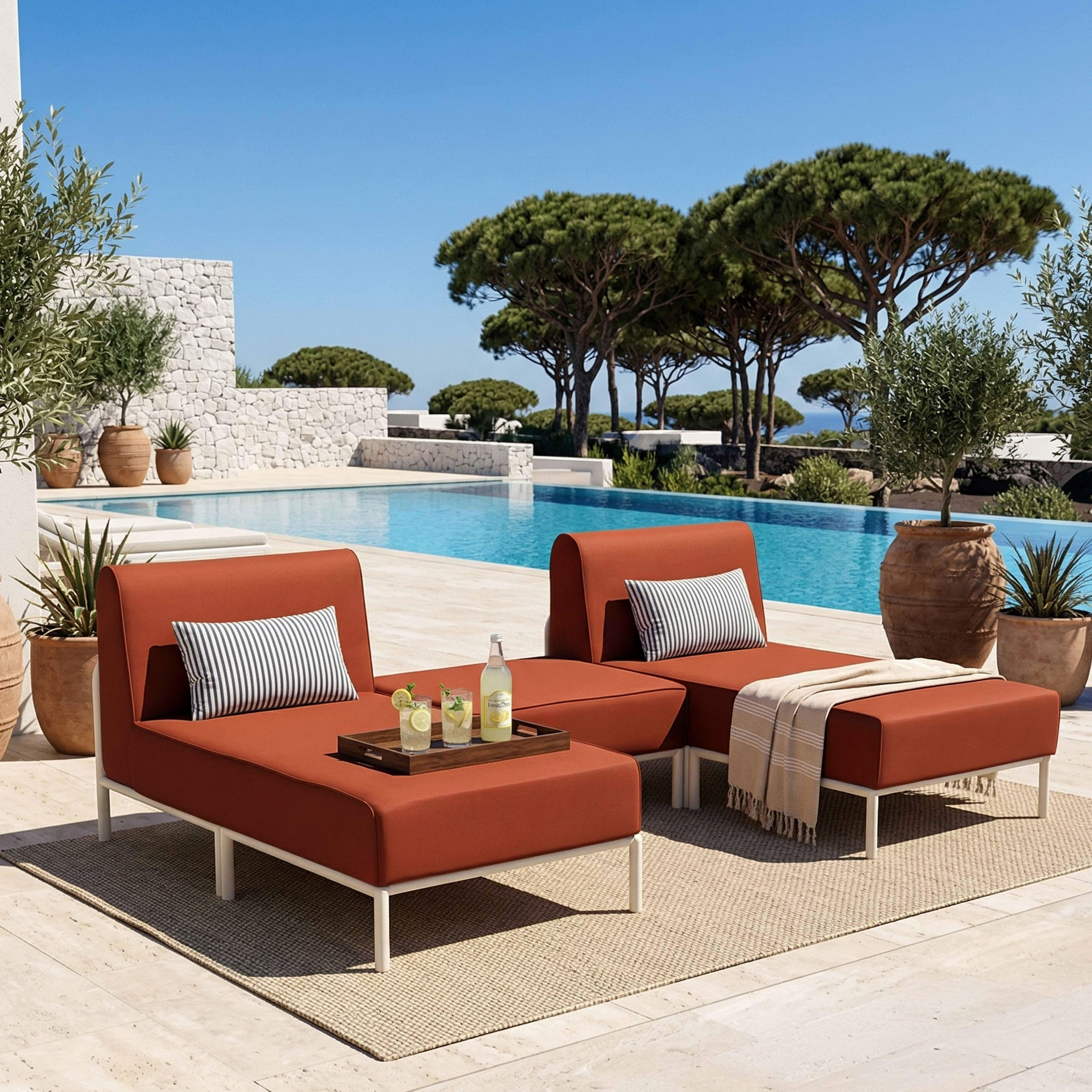 Rote Lounge-Möbel am Pool mit Getränken, gestreiften Kissen und Decke.