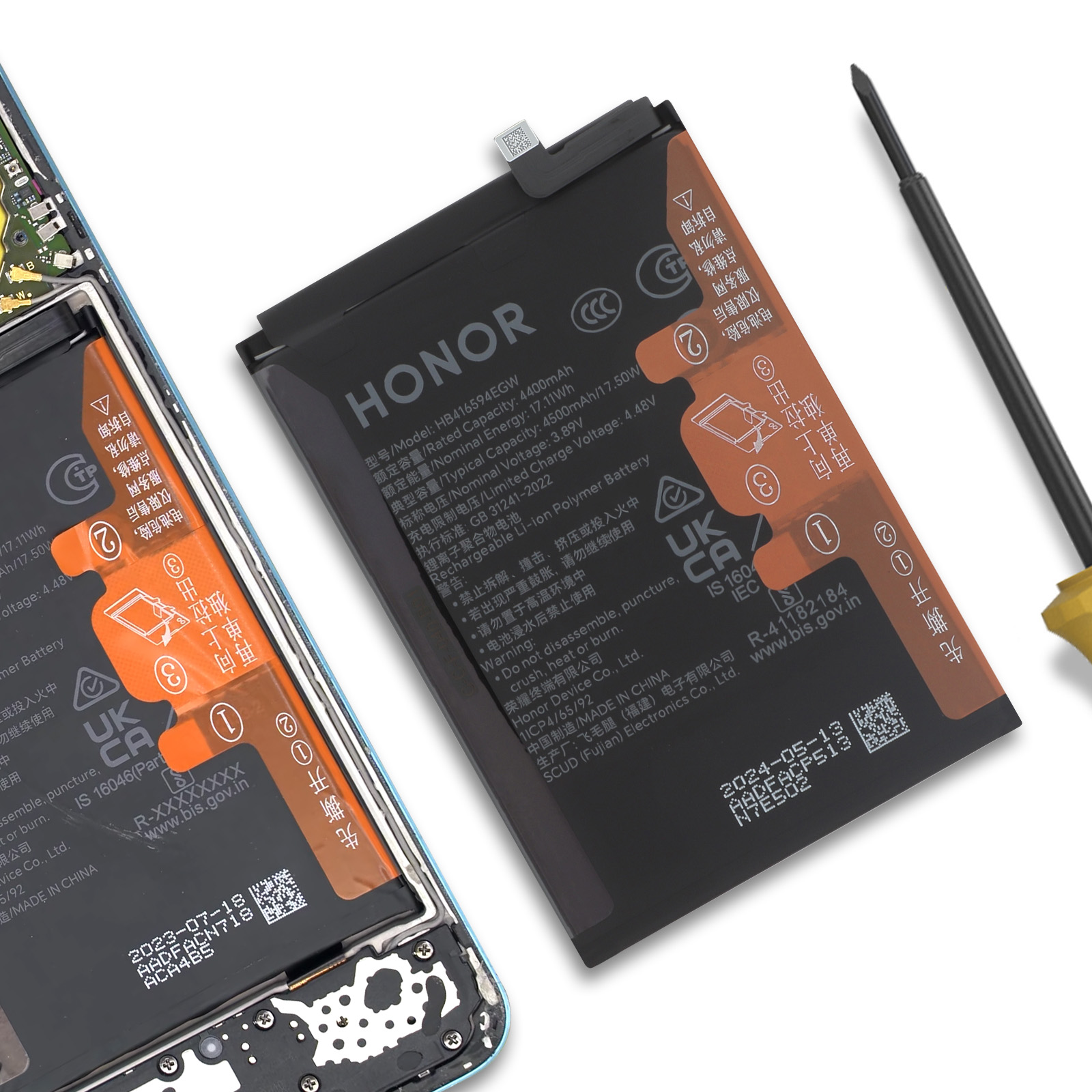 Una batería Honor, un destornillador y el interior de un smartphone sobre fondo blanco.