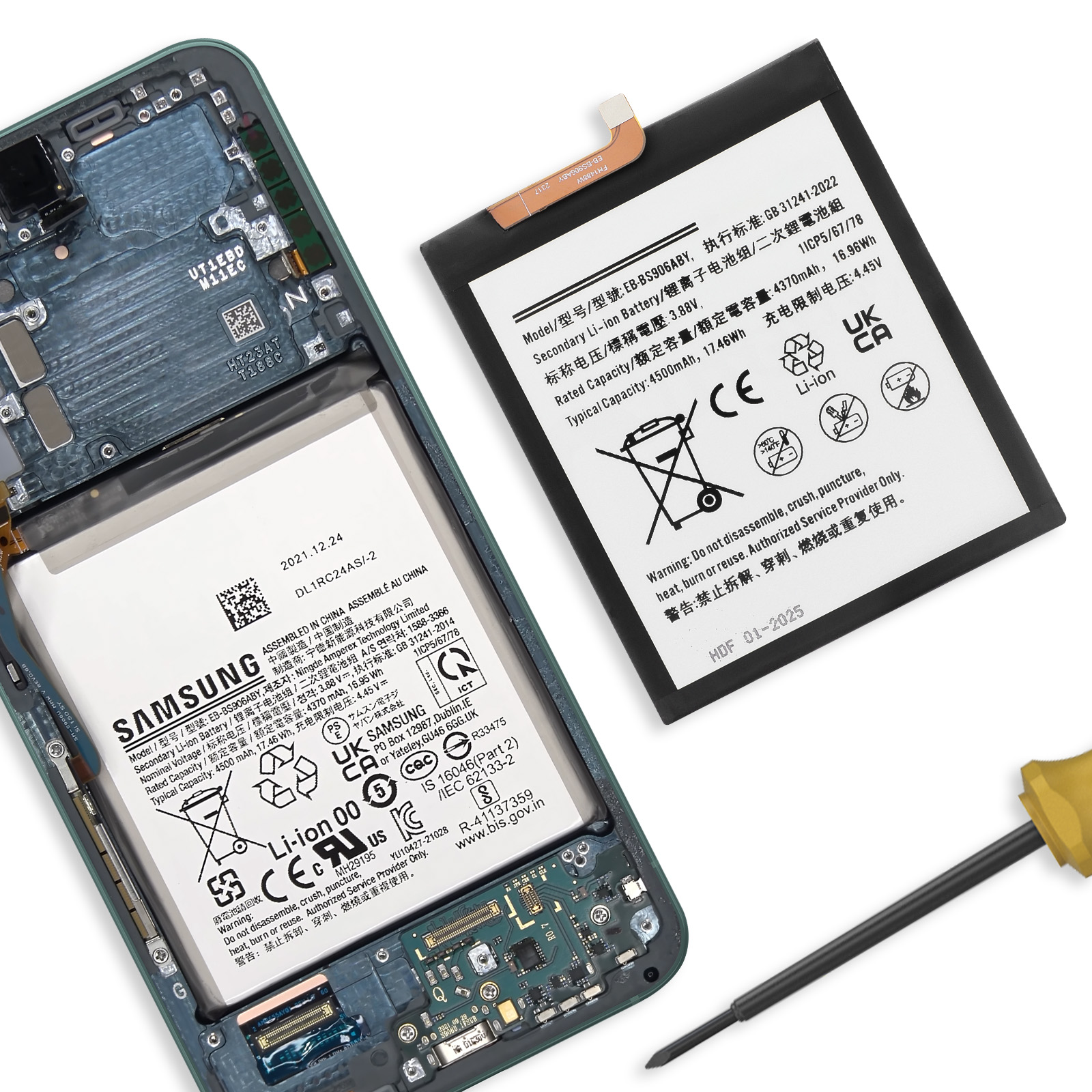 Una batteria per smartphone con logo Samsung e avvisi giace accanto a un telefono aperto.