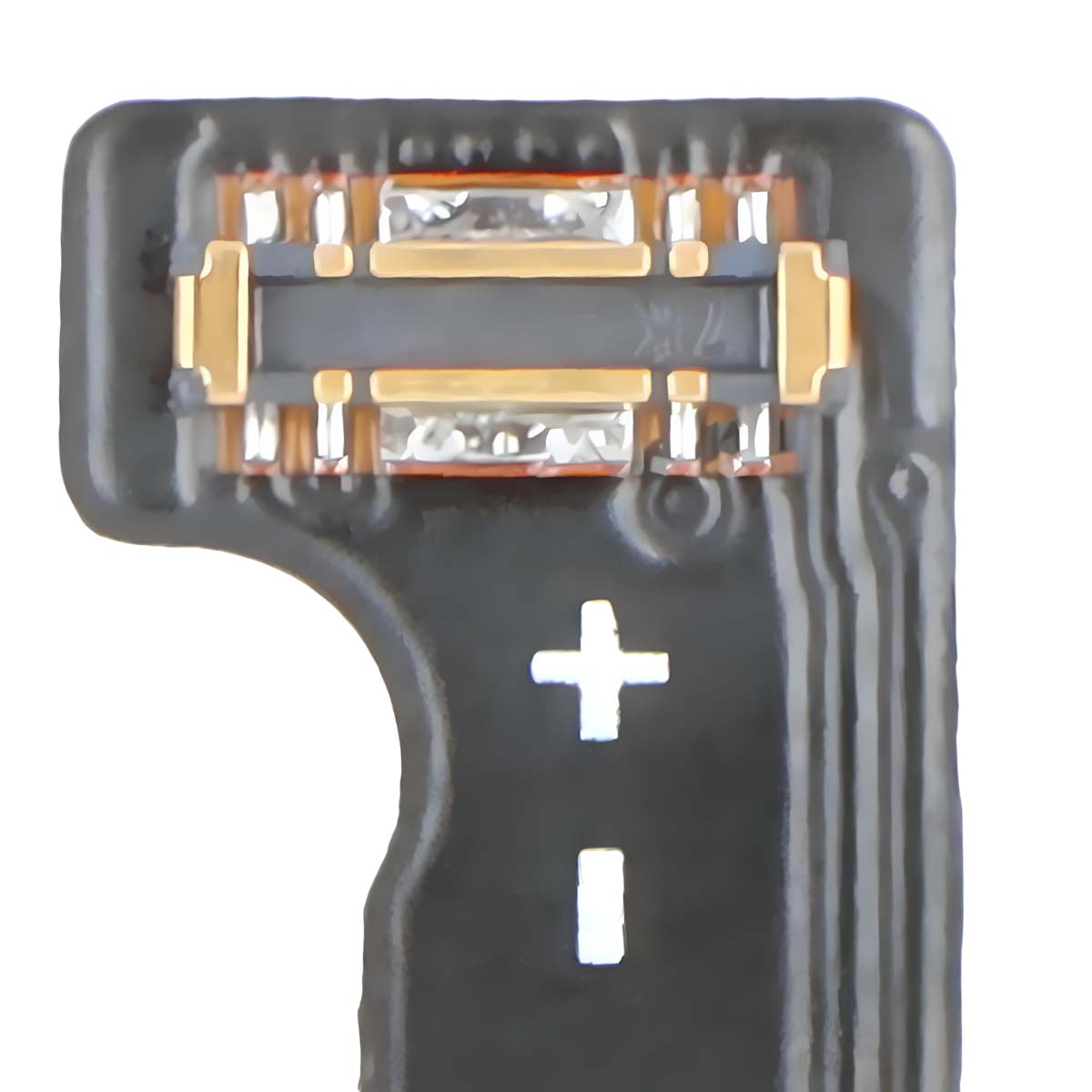 Primer plano de una placa de circuito negra con contactos dorados y un símbolo de más/menos.