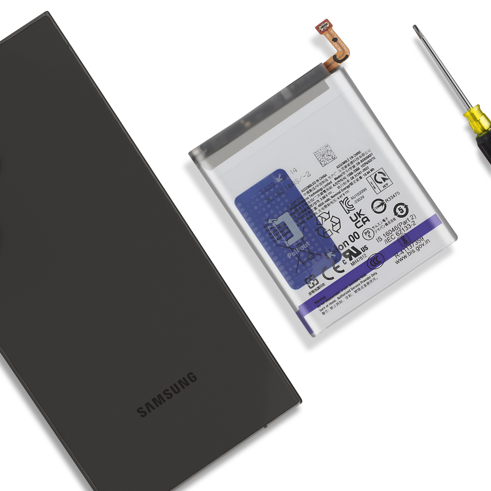 La tapa trasera negra de Samsung y la batería yacen sobre una superficie blanca junto a un destornillador.