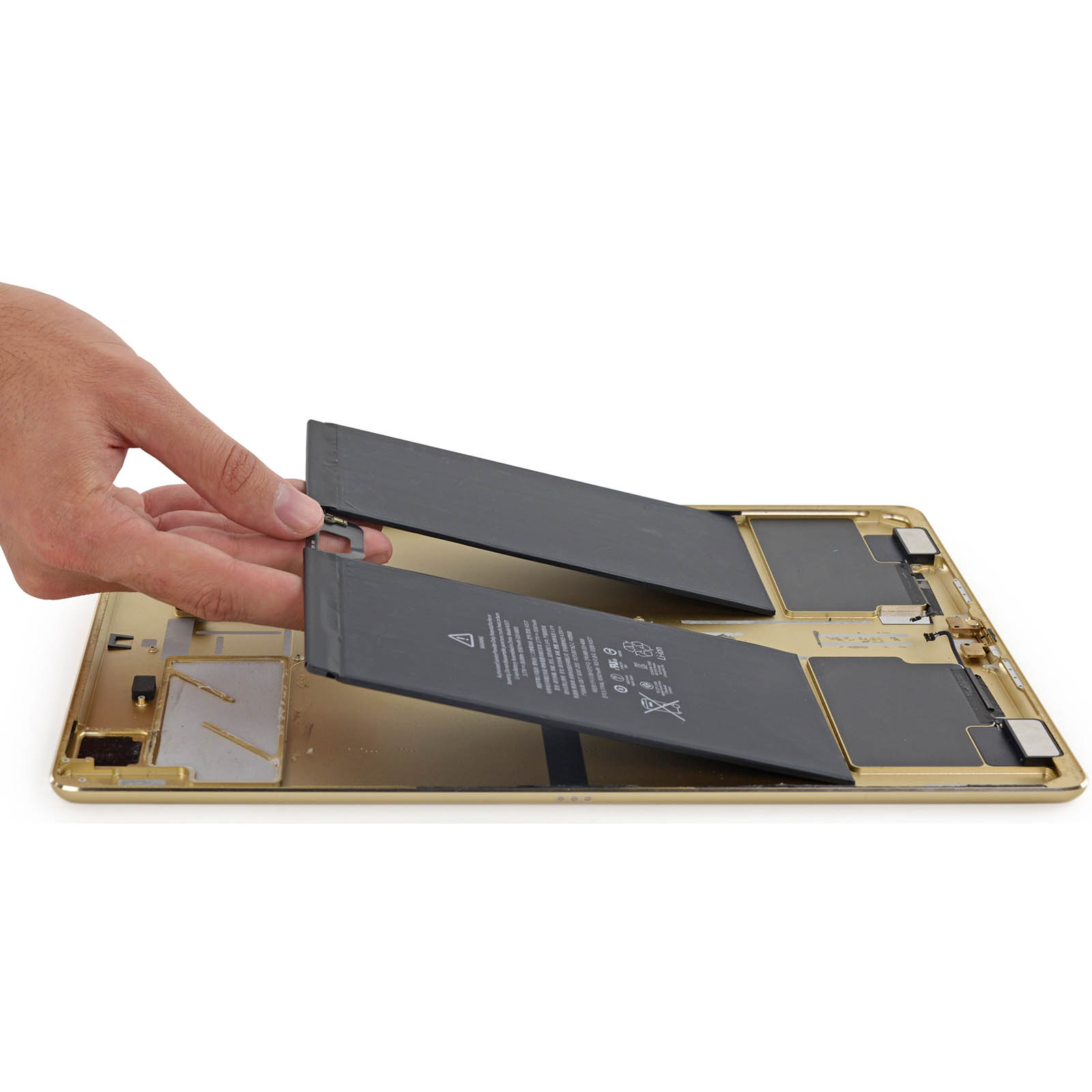Una mano solleva due batterie nere da una scocca dorata.