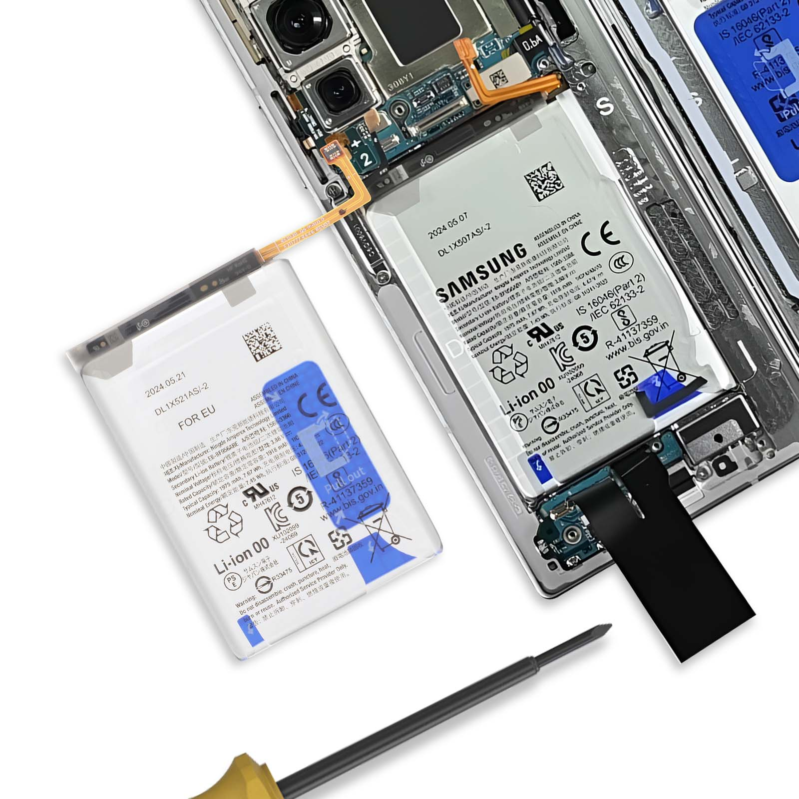 Componentes de smartphone desmontados: dos baterías, placa base, cables. Herramienta al frente.