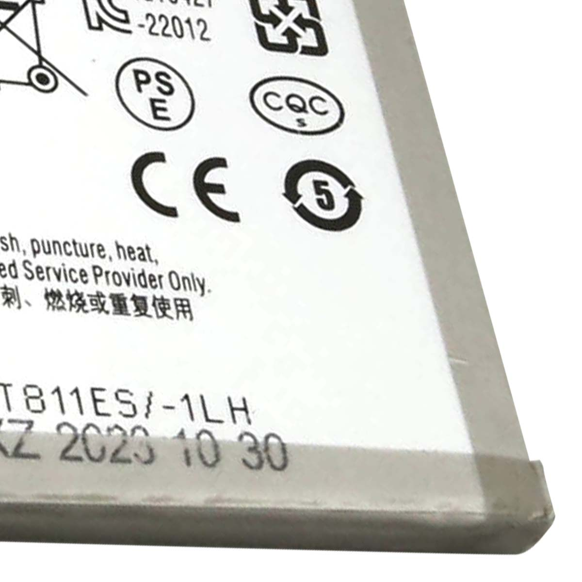 Primo piano di una batteria con sigilli di certificazione e data di produzione.