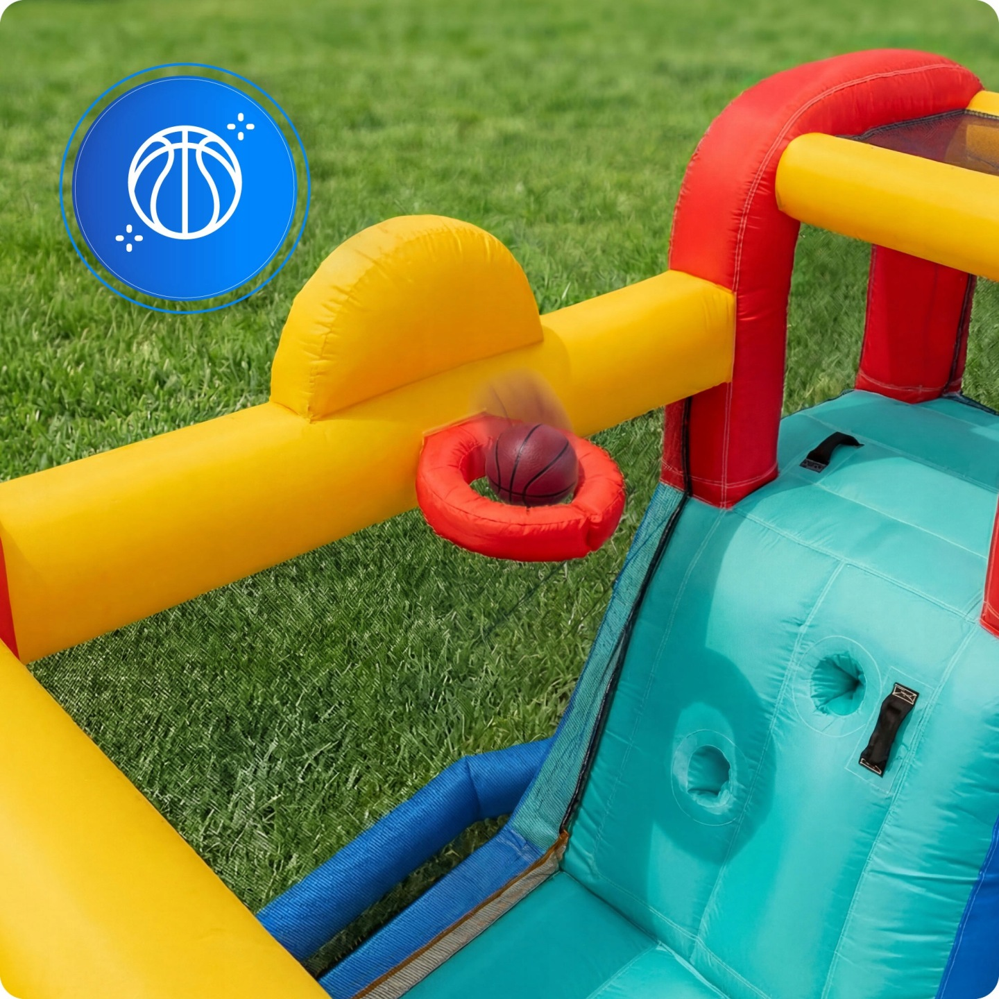 Ein aufblasbarer Basketballkorb auf grünem Rasen mit einem Ball, der hindurchfliegt.