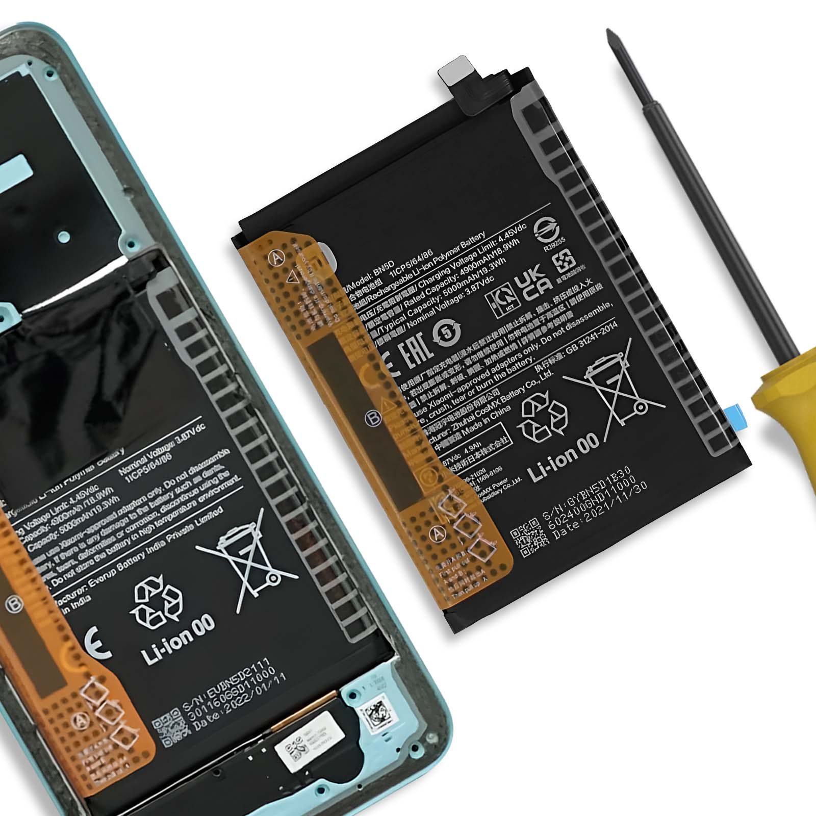 Una batteria per smartphone e un cacciavite giacciono su un tavolo.