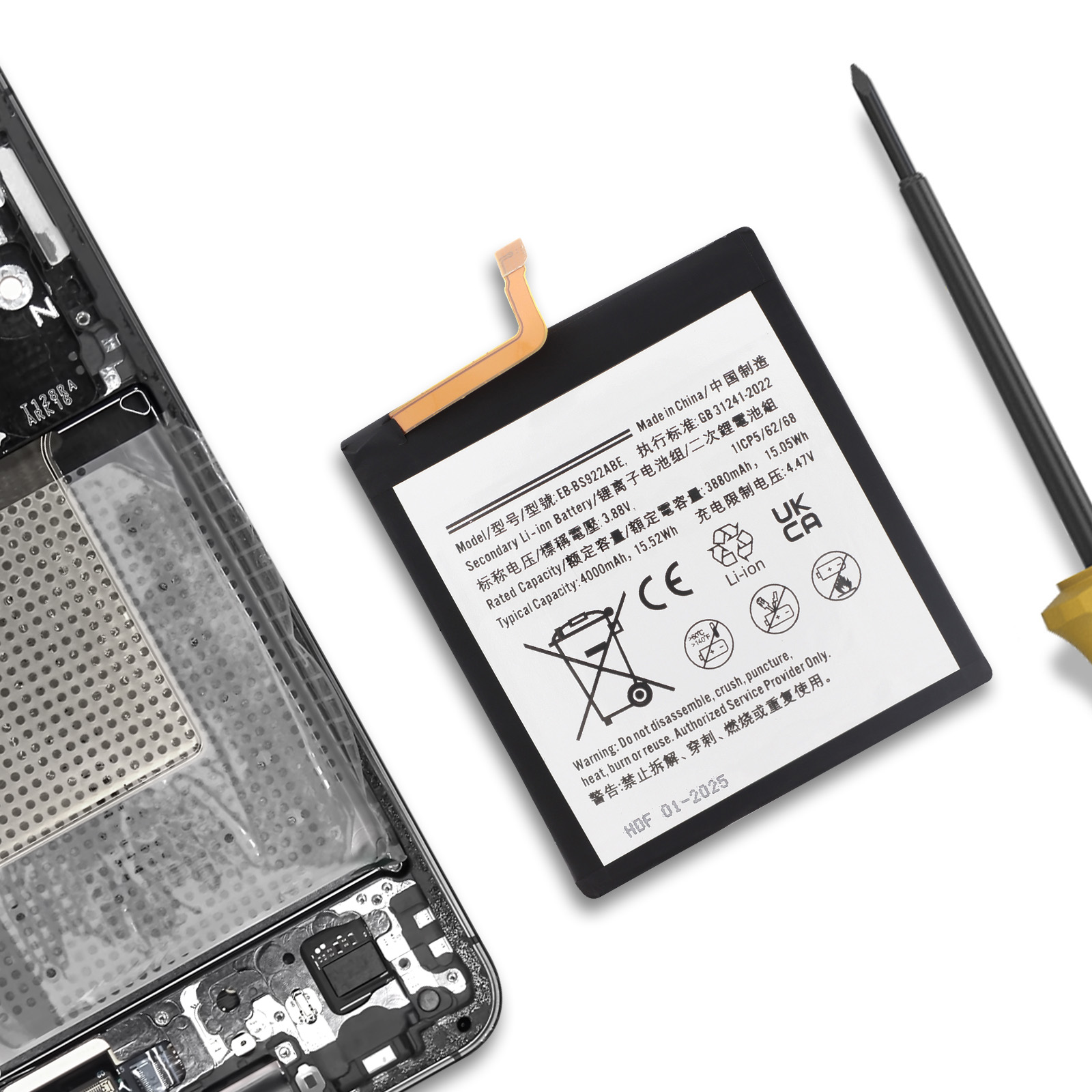Una batteria per smartphone con etichette giace accanto a un telefono aperto.