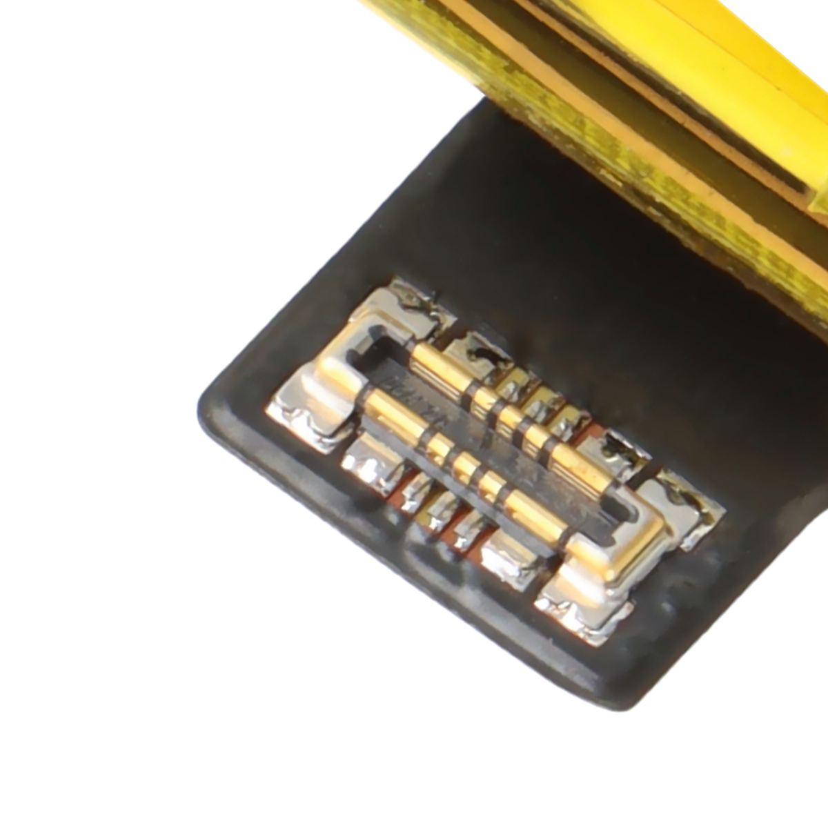 Nahaufnahme eines Batteriesteckers mit vergoldeten Kontakten auf schwarzer Oberfläche.
