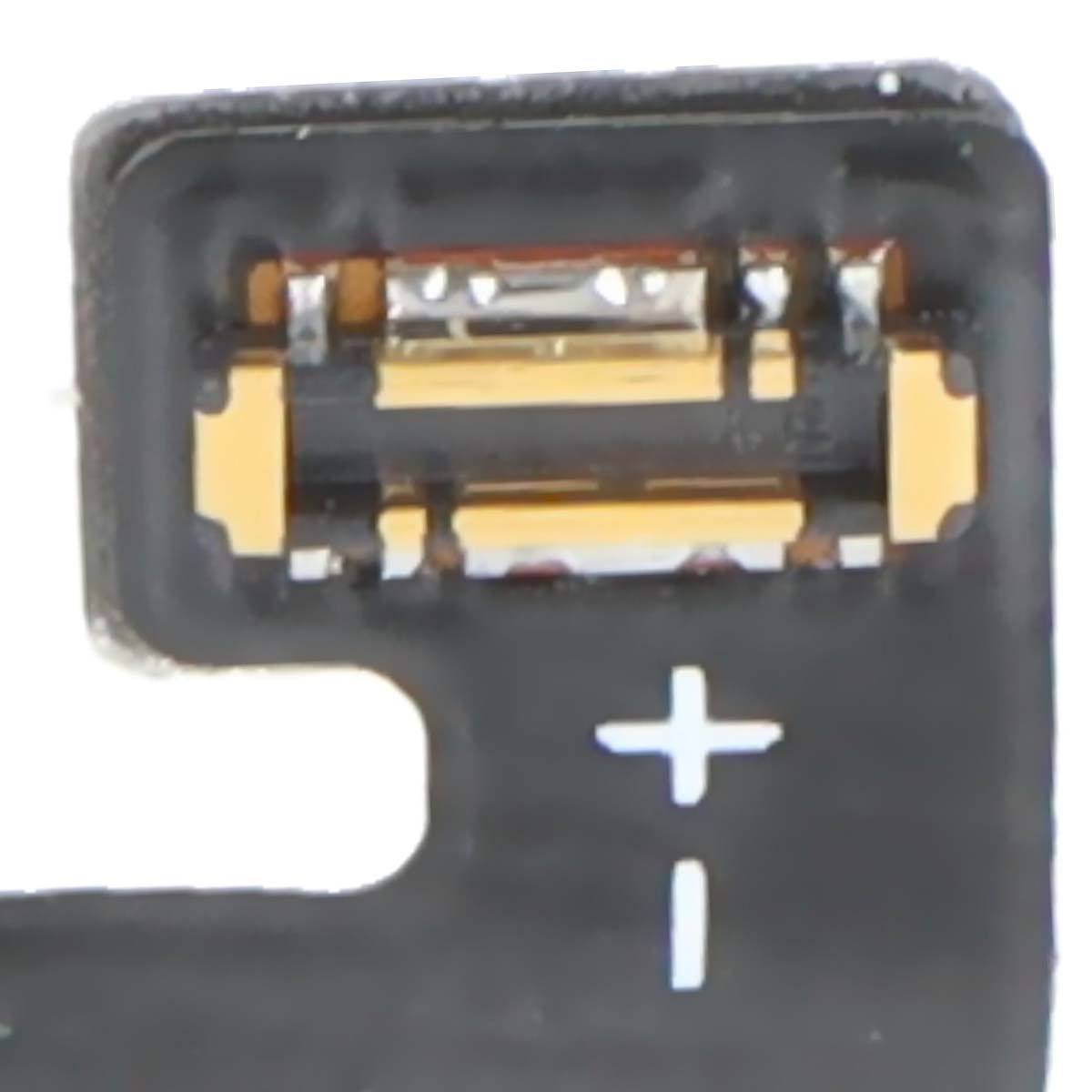 Ein Nahaufnahme eines schwarzen Anschlusses mit goldenen und silbernen Kontakten und einem Plus-Minus-Symbol.