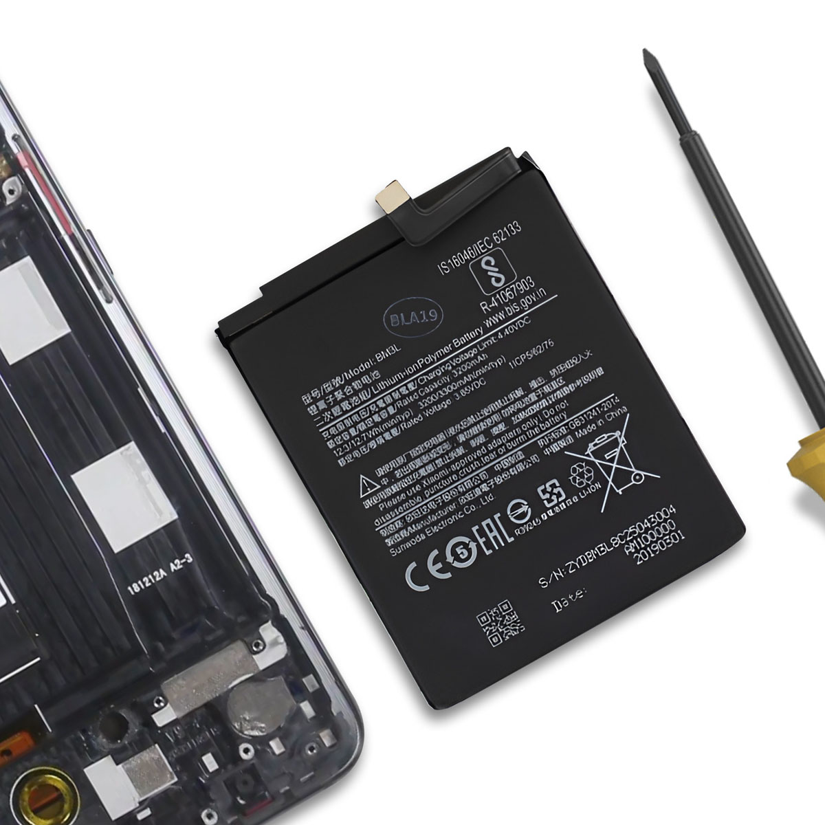 Una batteria per smartphone con testo e un cacciavite giacciono su un tavolo.