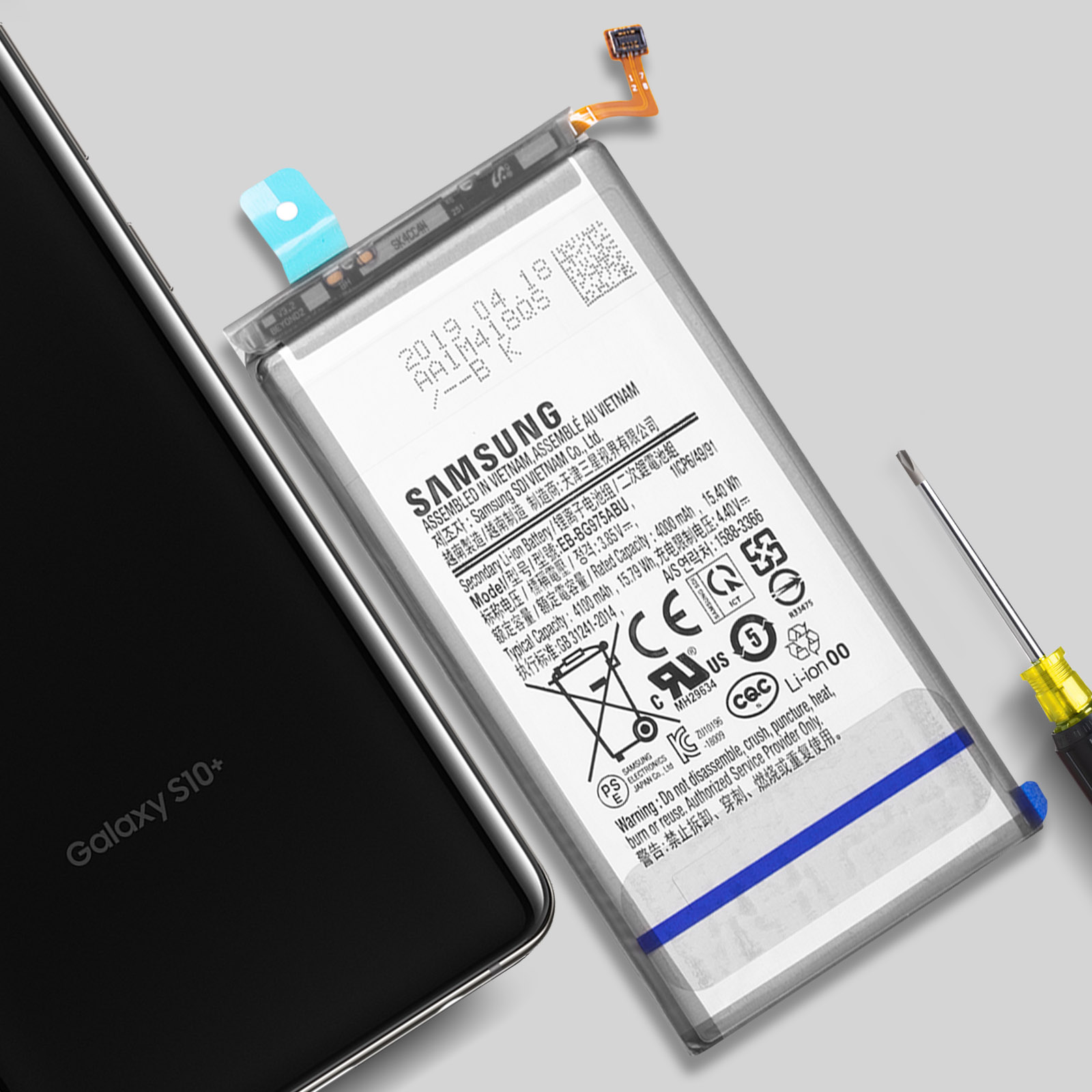Ein Samsung Galaxy S10+ Akku und ein Smartphone liegen daneben, mit einem Schraubenzieher.