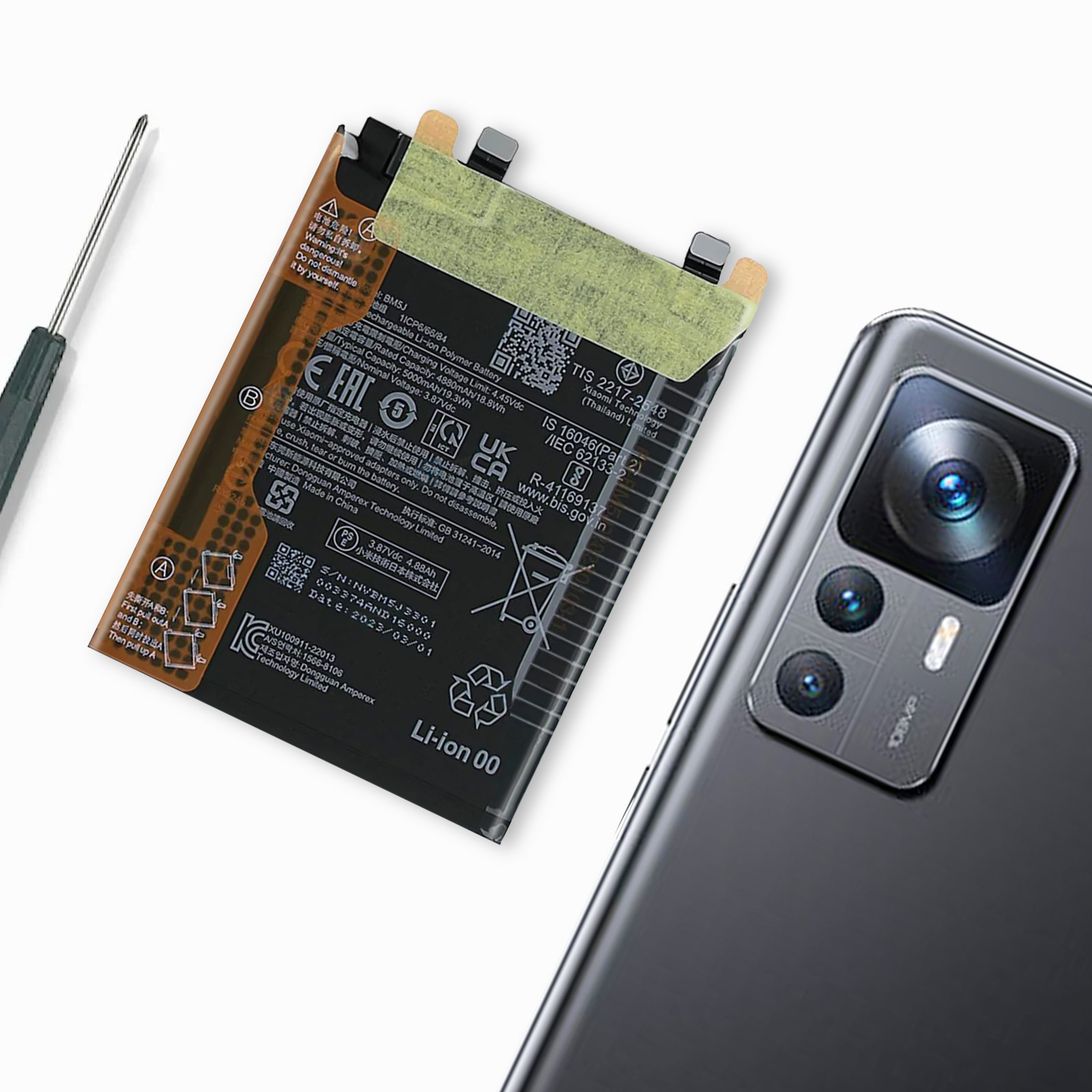 Uno smartphone e una batteria giacciono uno accanto all'altro. Un cacciavite è a sinistra.