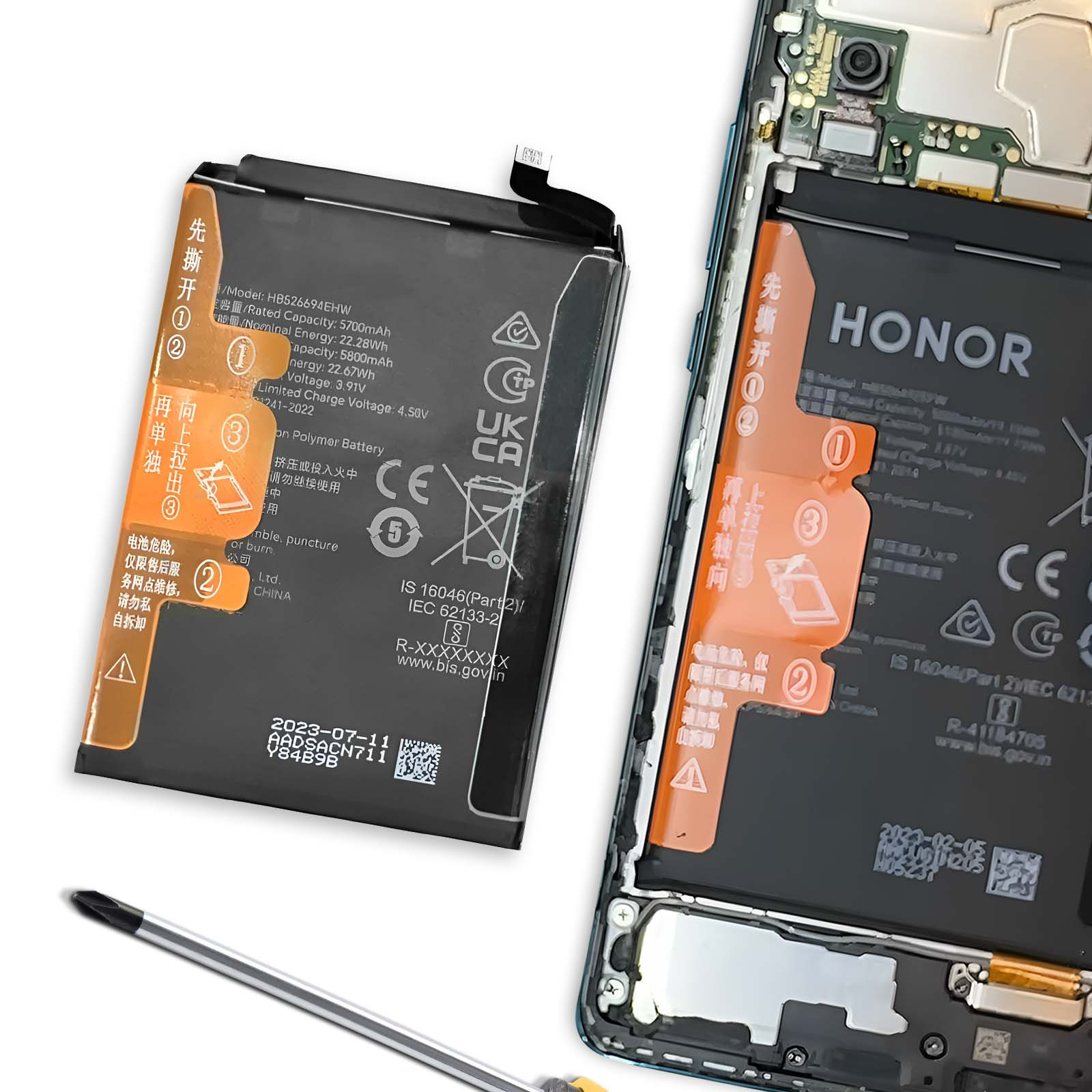 Una batteria per smartphone giace accanto a uno smartphone aperto con elettronica esposta.