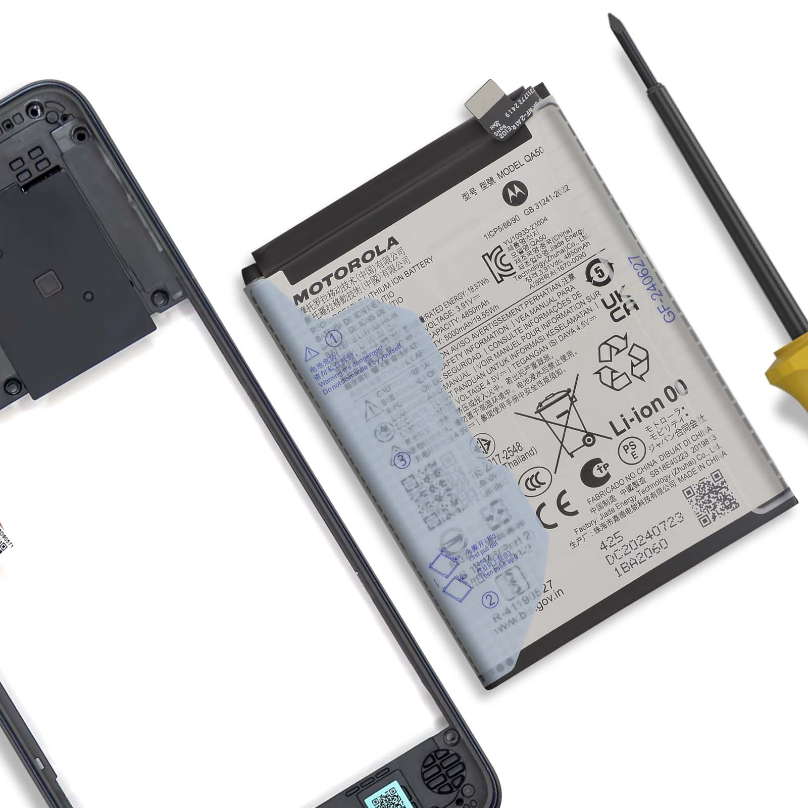 Una batteria Motorola e un telaio del telefono giacciono su una superficie bianca. Un cacciavite è a destra.
