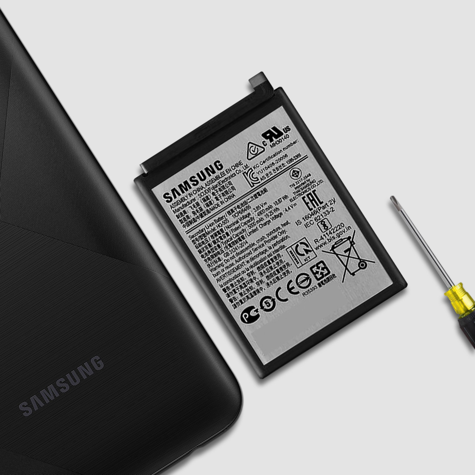 Smartphone Samsung noir avec batterie et tournevis Samsung, gros plan.