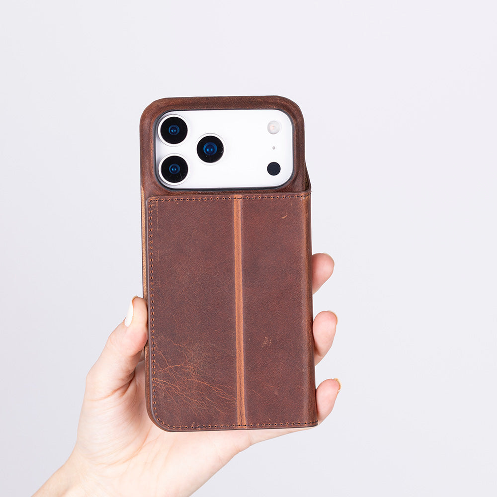 Bir el, üç kameralı kahverengi deri iPhone kılıfı tutuyor.