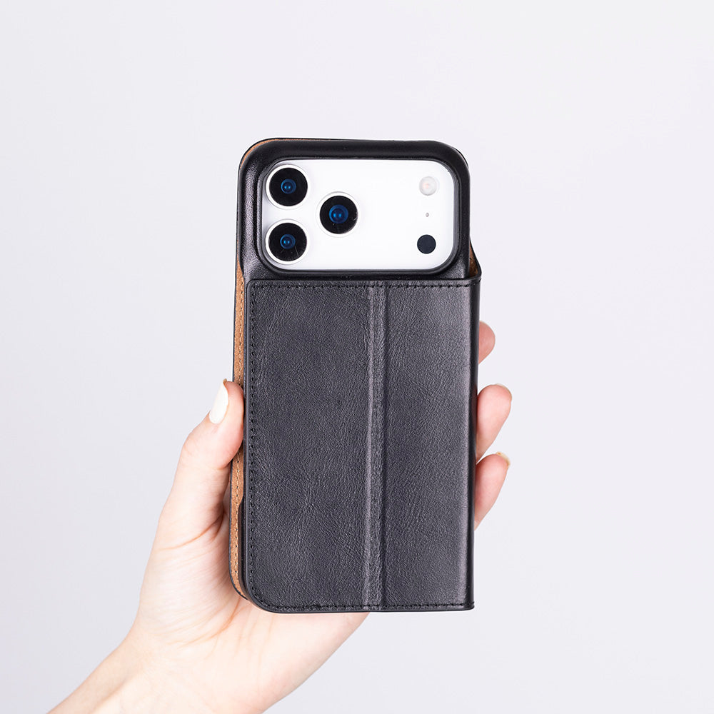 Bir el, üç kamera lensli siyah bir iPhone tutuyor.