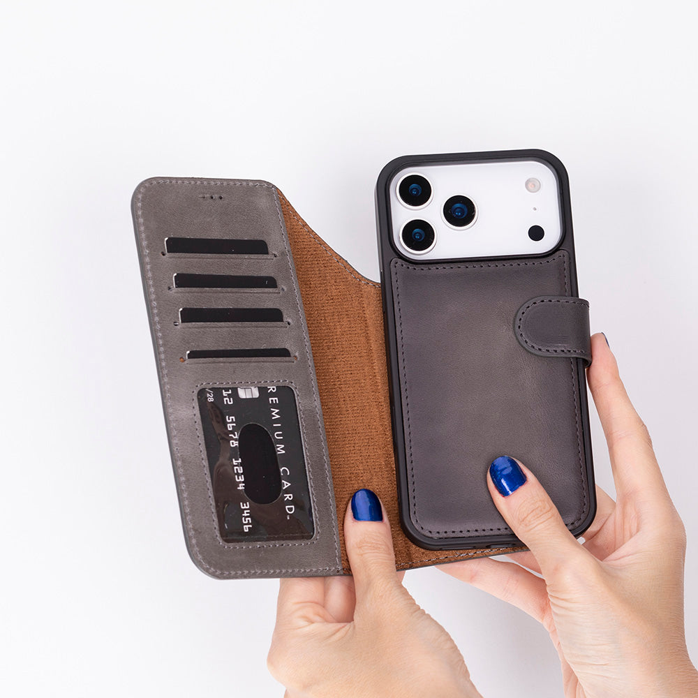Kart yuvalı ve görünür kartlı gri telefon kılıfı, eller tarafından tutuluyor.