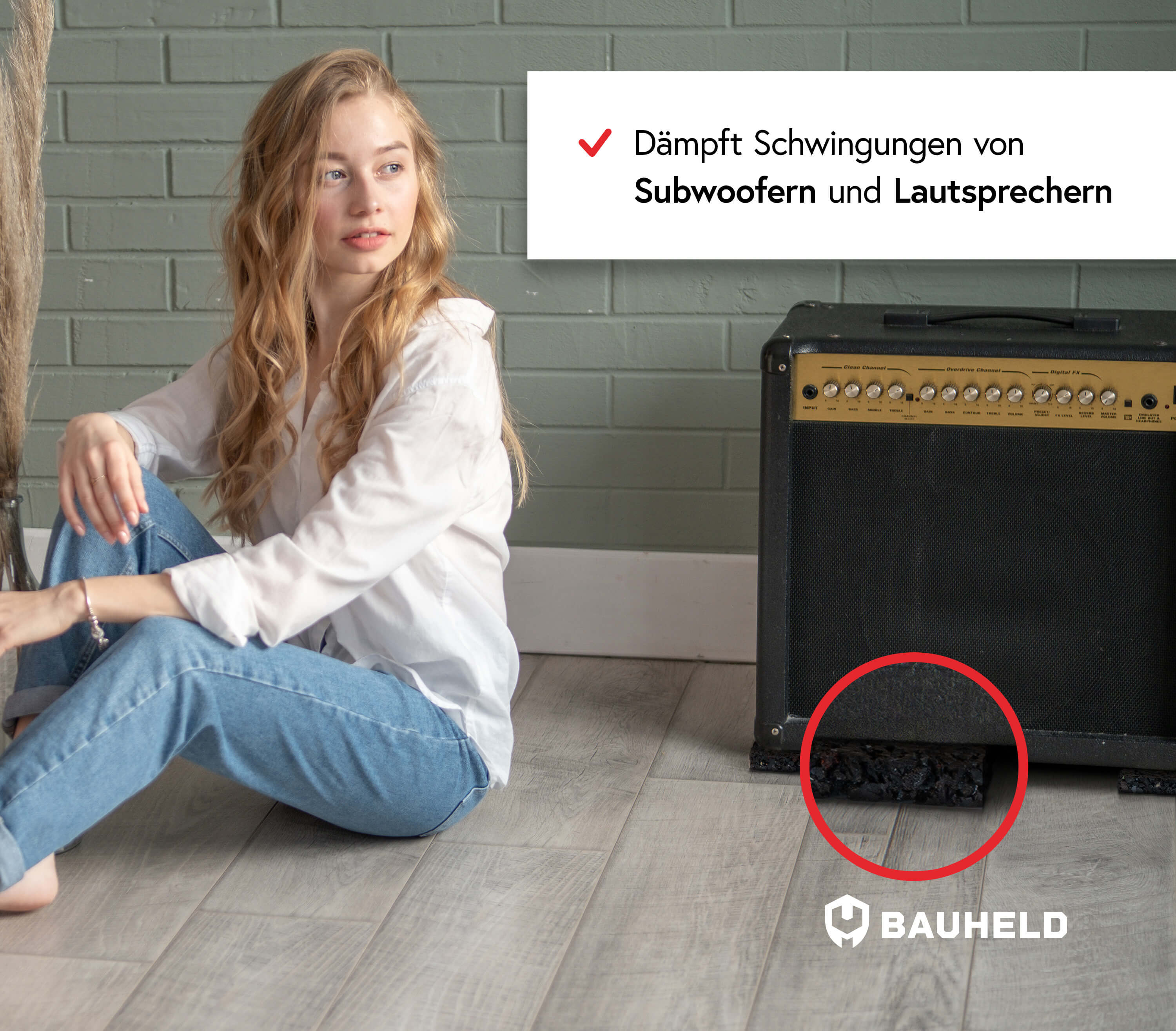 Junge Frau sitzt neben einem Gitarrenverstärker auf einem Holzboden.