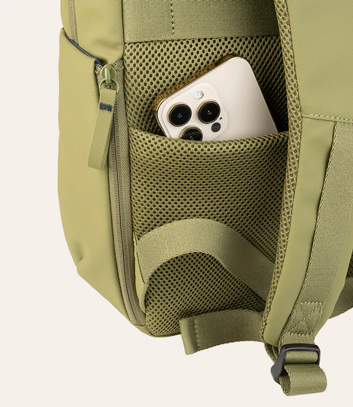 Uno smartphone nella tasca laterale in rete di uno zaino verde oliva.