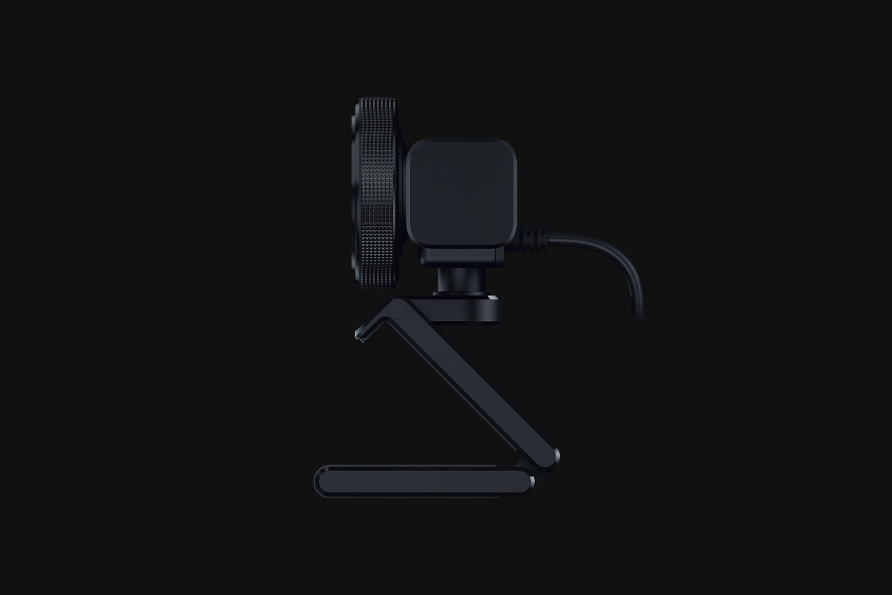 Una webcam nera con supporto regolabile e cavo, isolata su sfondo nero.