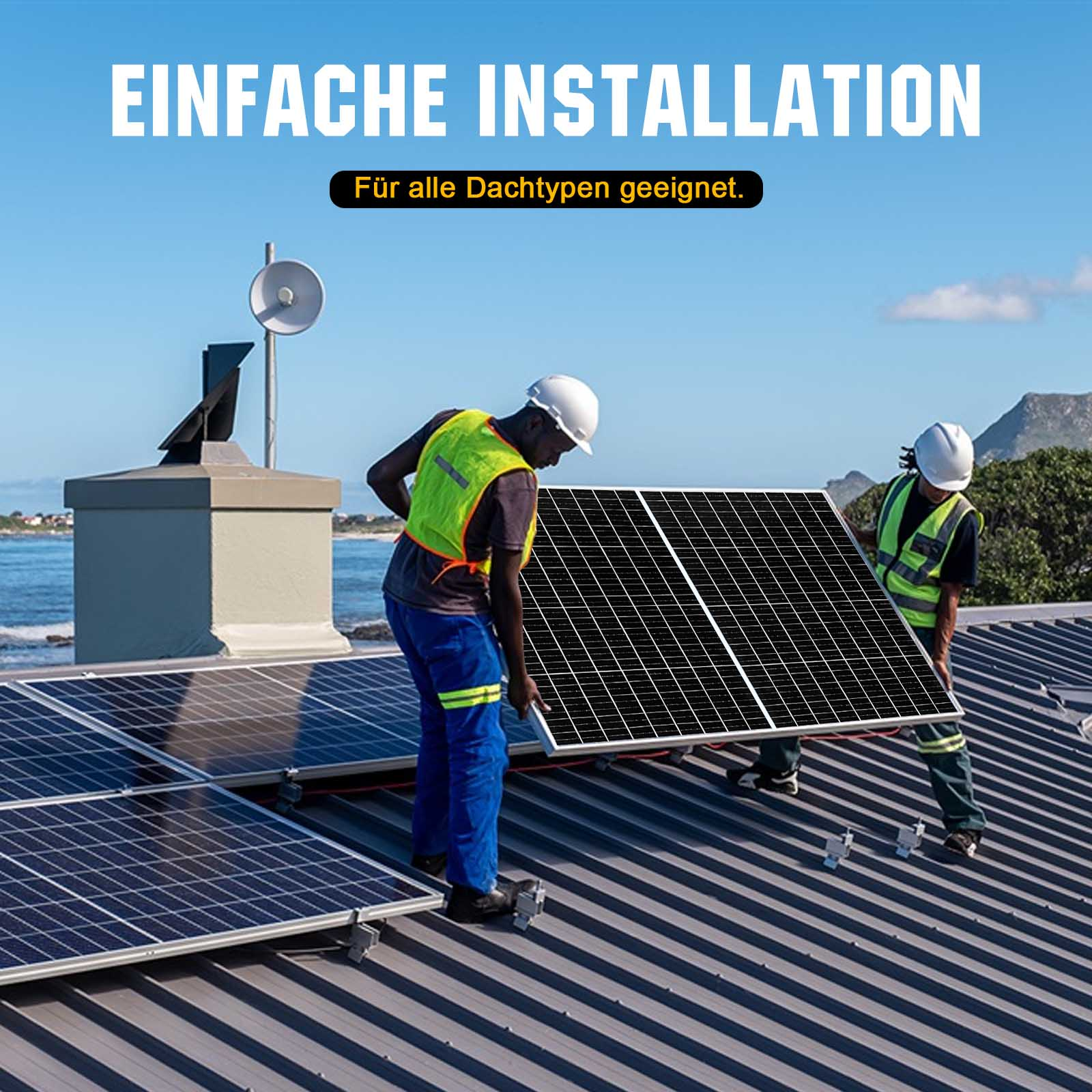 Zwei Männer installieren Solarmodule auf einem Metalldach, Meer im Hintergrund.