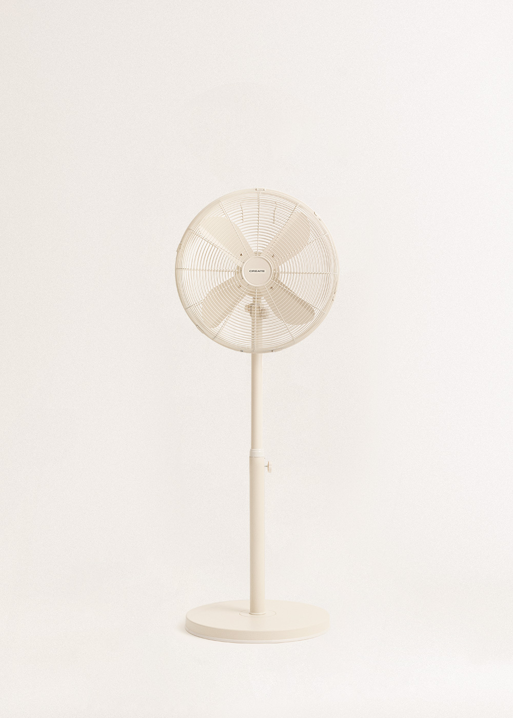 Un ventilador de pie color crema con base redonda y pie ajustable.