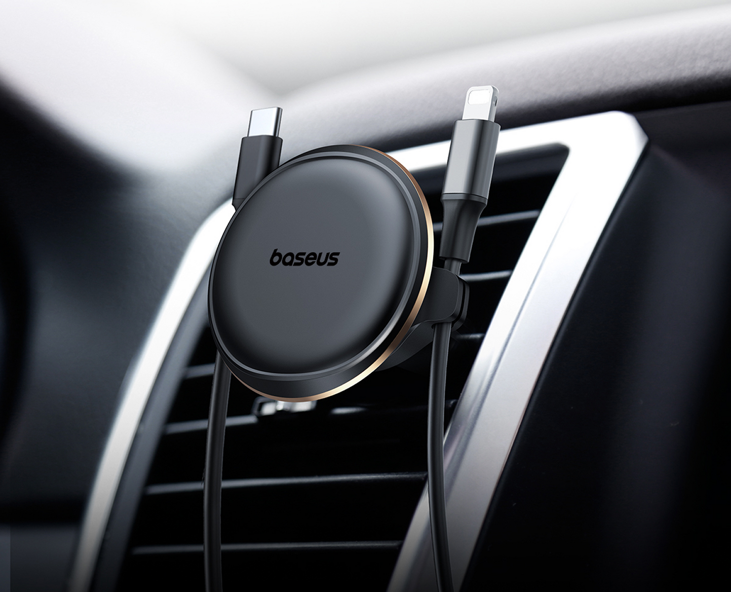 Czarny uchwyt samochodowy Baseus z kablami USB-C i Lightning przymocowany do nawiewu samochodu.