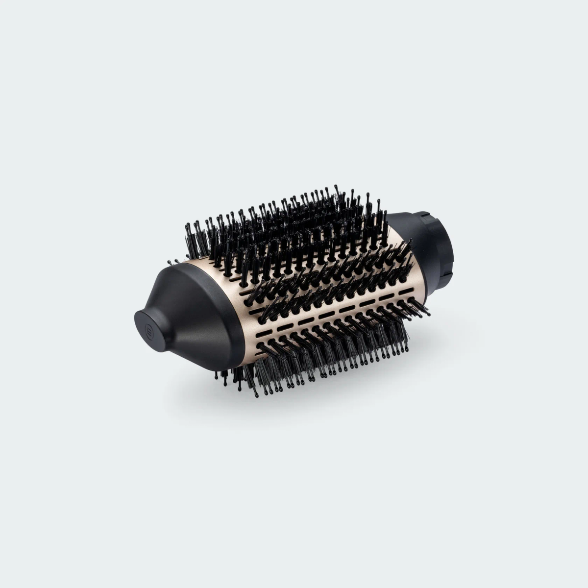 Un accessorio spazzola tonda per capelli, nero e oro, con setole dense, su sfondo grigio.