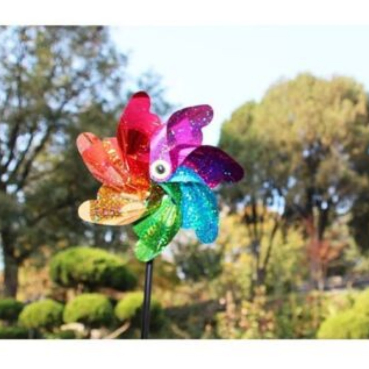 Colorful pinwheel in a garden with sparkling petals.