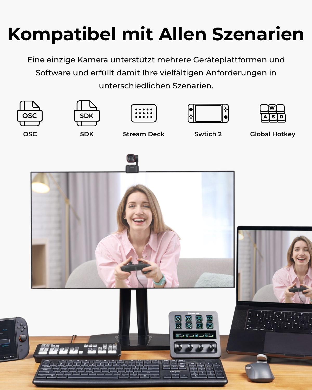 Eine Frau spielt mit einem Gamecontroller vor einem Monitor und Laptop.