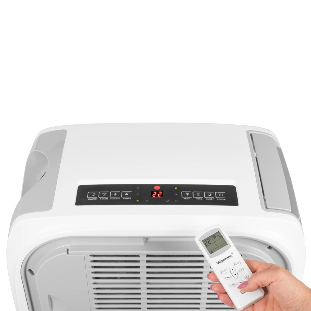 Dłoń trzyma pilot do białej klimatyzacji z cyfrowym wyświetlaczem.