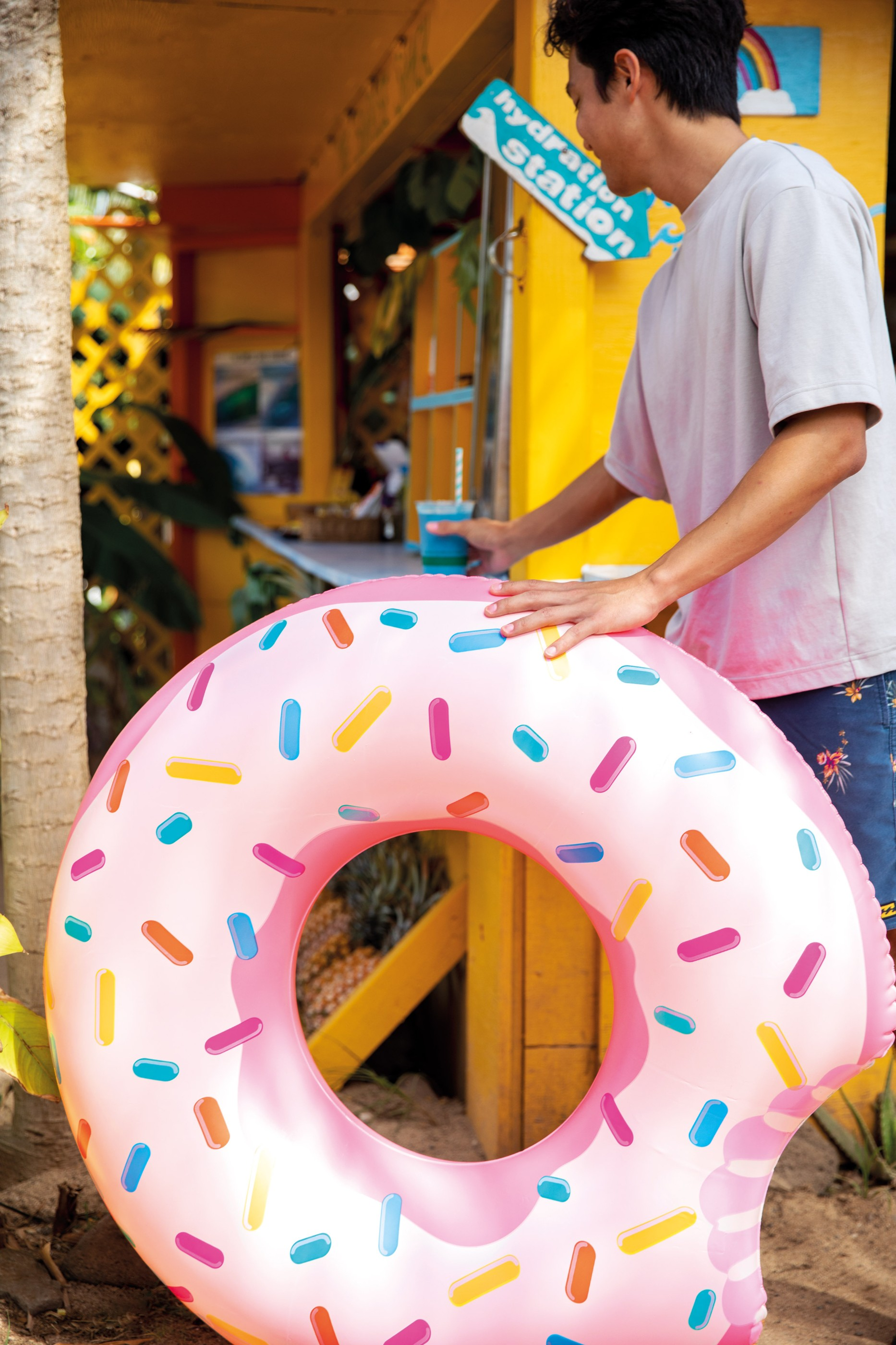 Mężczyzna stoi przy żółtej budce z napisem "Hydration Station".