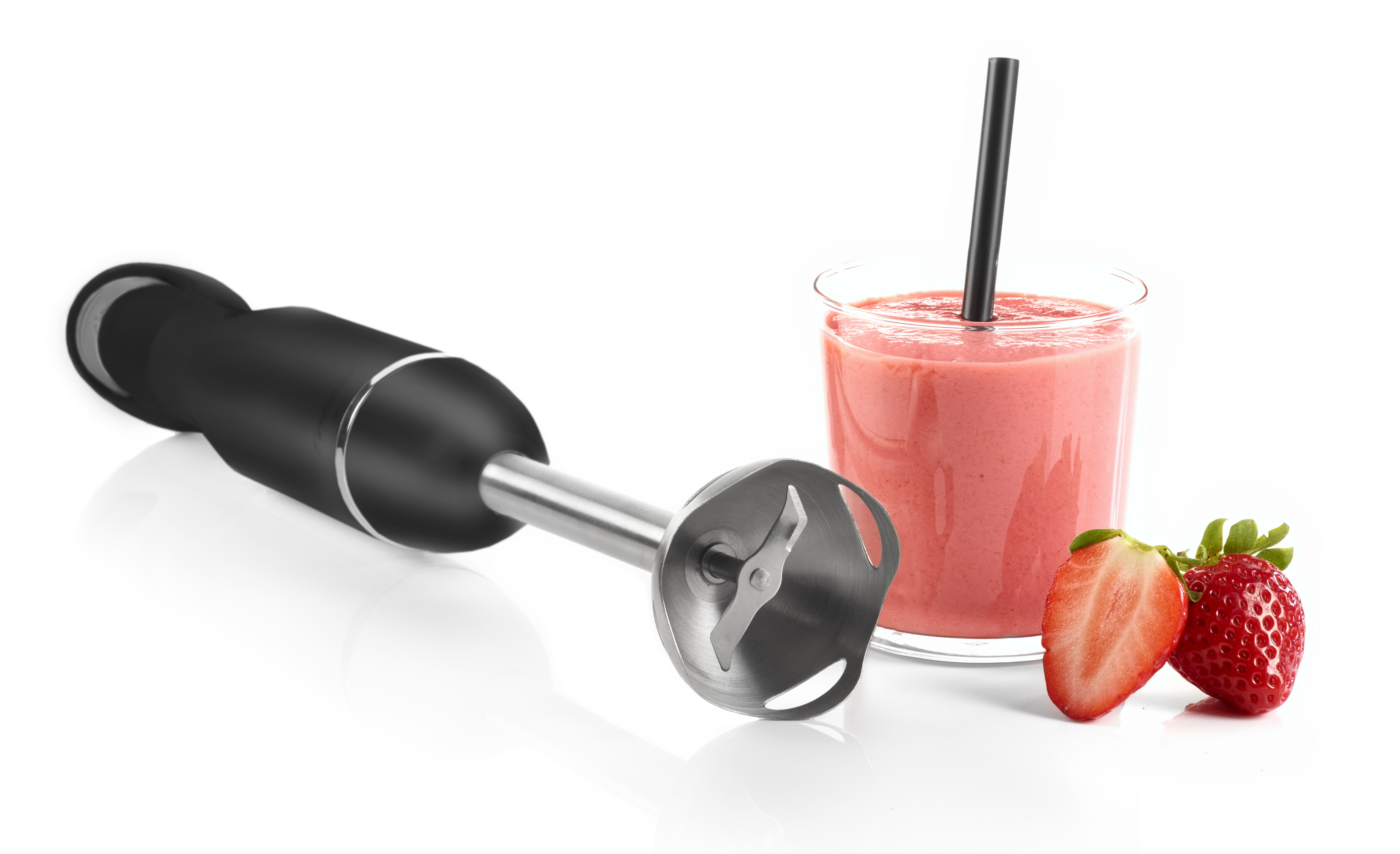 Ein schwarzer Stabmixer mit einem Glas Erdbeersmoothie und Erdbeeren daneben.