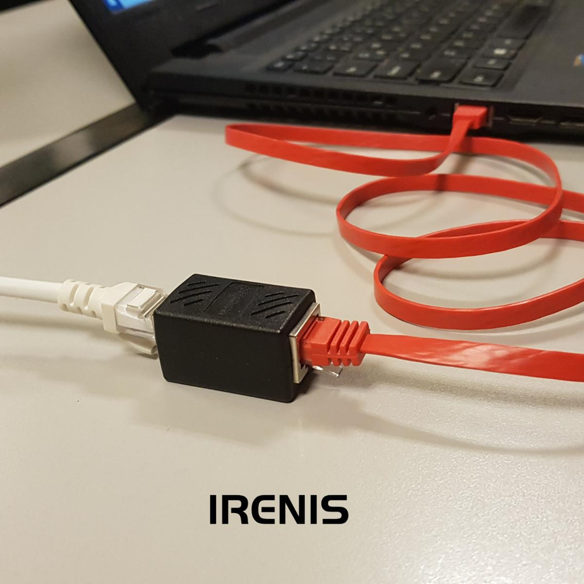 Siyah bir ağ adaptörü, beyaz ve kırmızı Ethernet kablosunu birbirine bağlar. Arka planda bir dizüstü bilgisayar var.