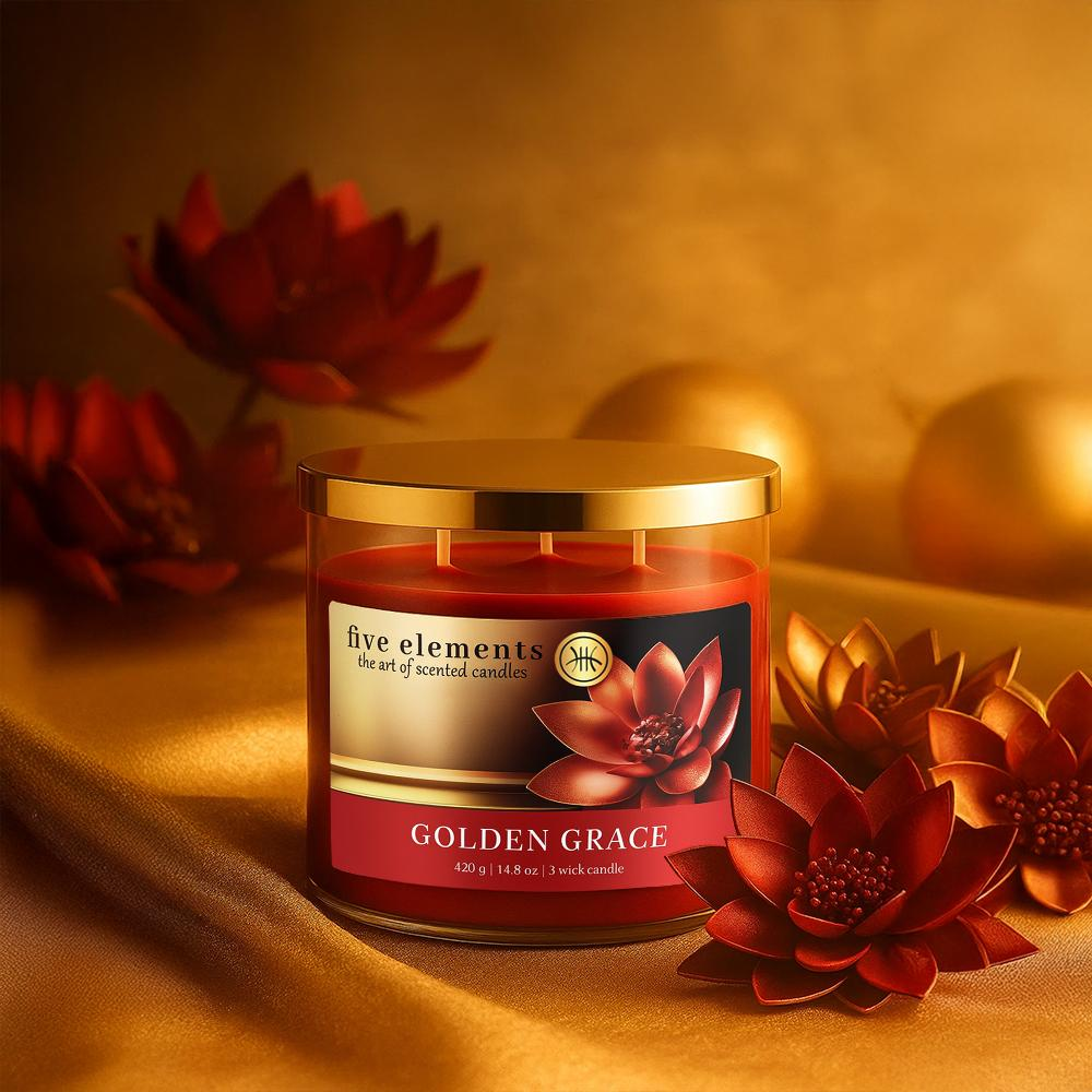 Ein roter Kerzenbehälter mit goldenem Deckel auf goldener Seide, umgeben von roten Blüten.