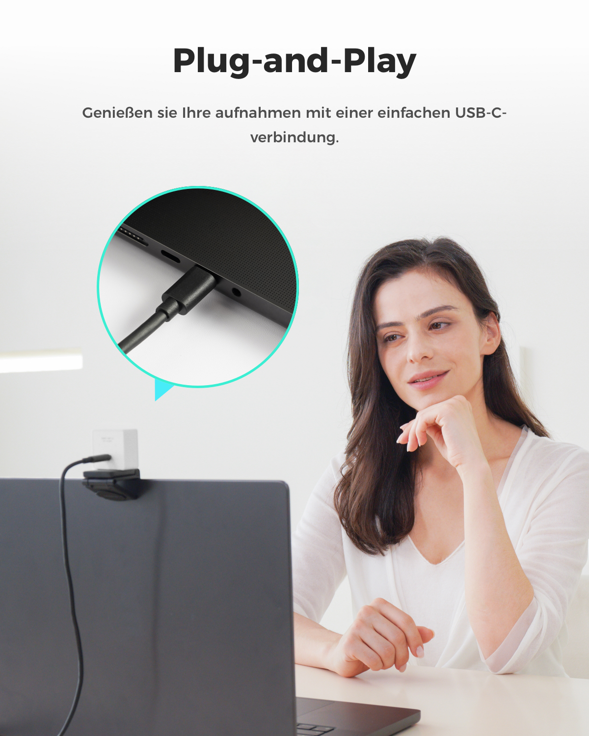 Eine Frau sitzt vor einem Laptop, während ein USB-C-Kabel angeschlossen wird.